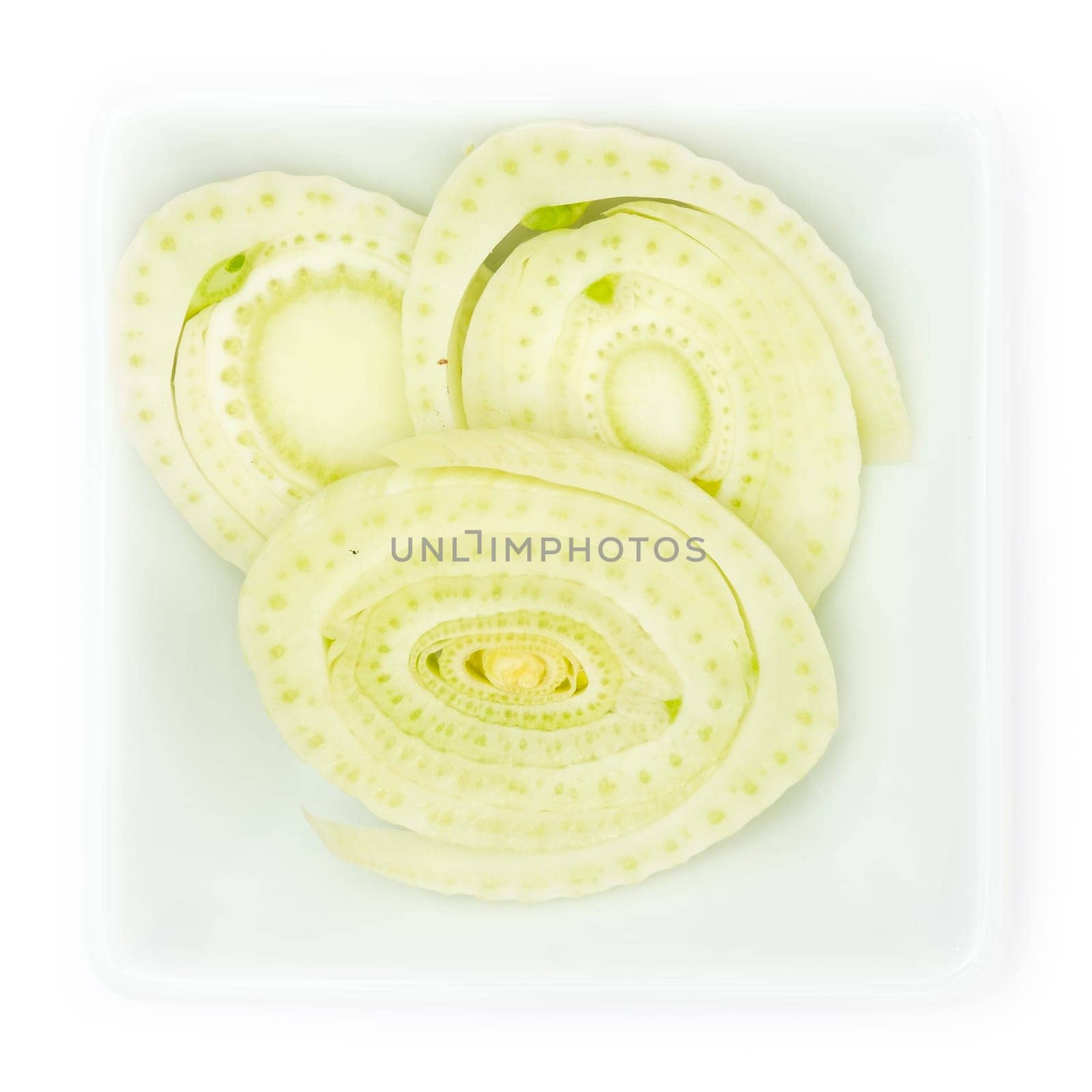 Sliced fennel in a white square bowl in top view