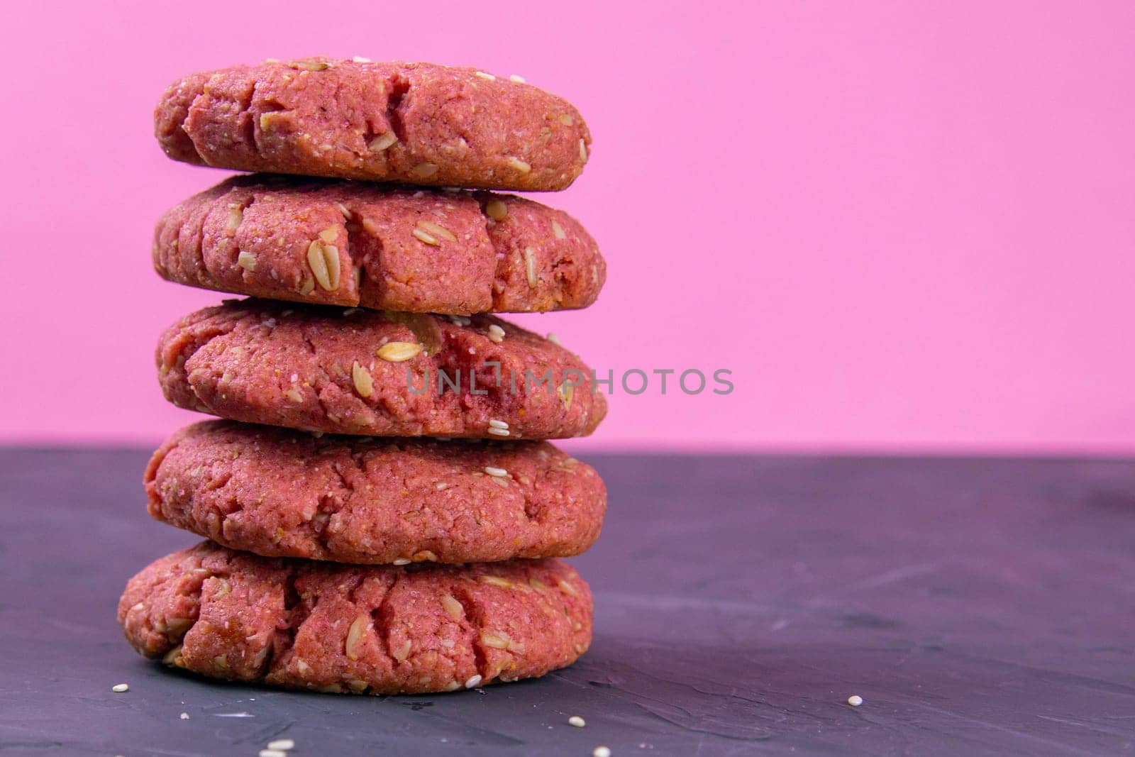 Oatmeal and beet cookies, on a on black wooden table. Food, holiday, cooking, baking background. Concept of home and healthy eating. Front views with clear space.
