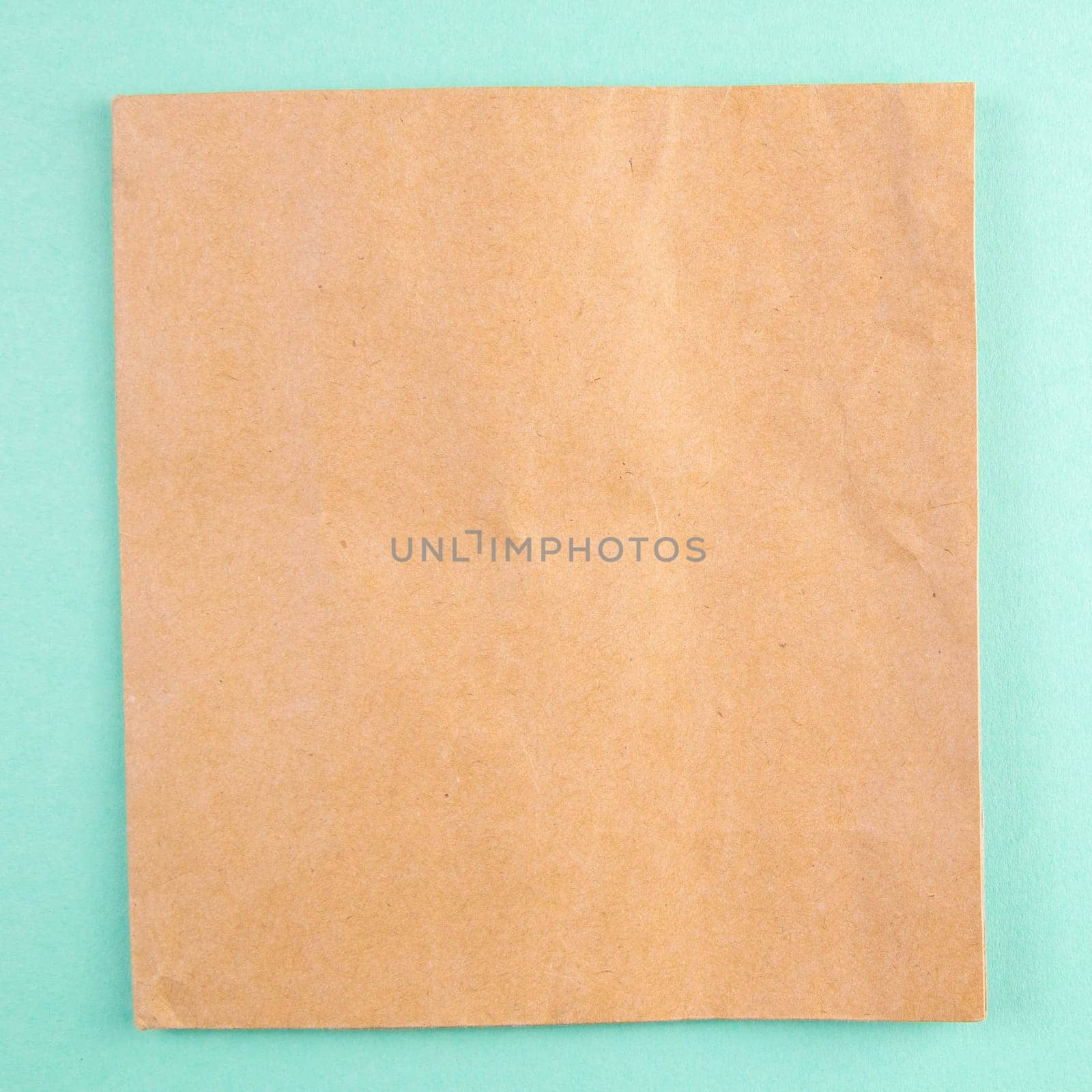 A sheet of craft paper on a mint background.