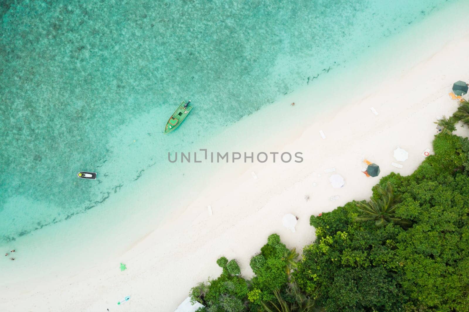 Aerial drone view of picture perfect beach and turquoise lagoon on small tropical island on Maldives.