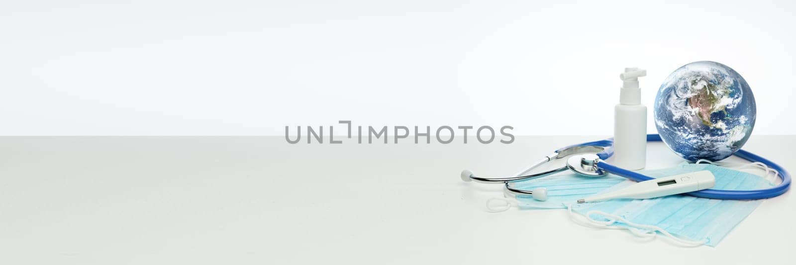 COVID-19. World globe with stethoscope, medical masks, sanitizer, thermometer. Global quarantine, infection prevention. Elements of this image furnished by NASA. Extra wide panorama banner background