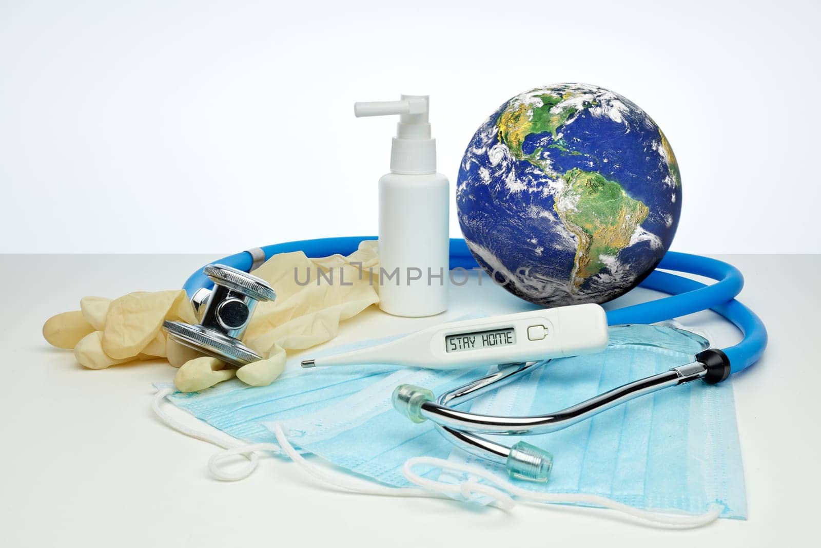 COVID-19. World globe with stethoscope, medical masks, sanitizer, thermometer on white background. Global quarantine, infection prevention, coronavirus. Elements of this image furnished by NASA