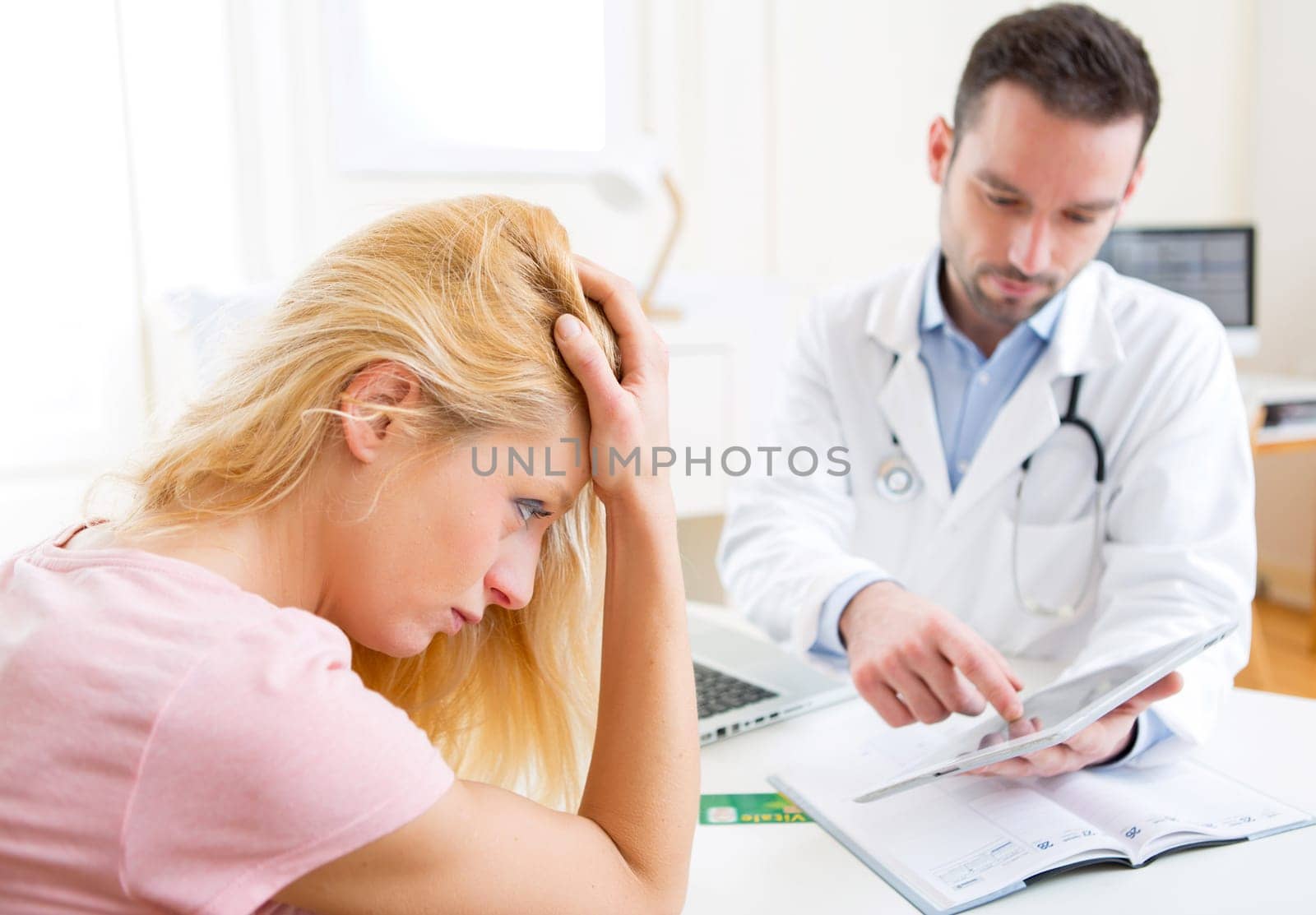 View of a Young doctor showing results on tablet to patient