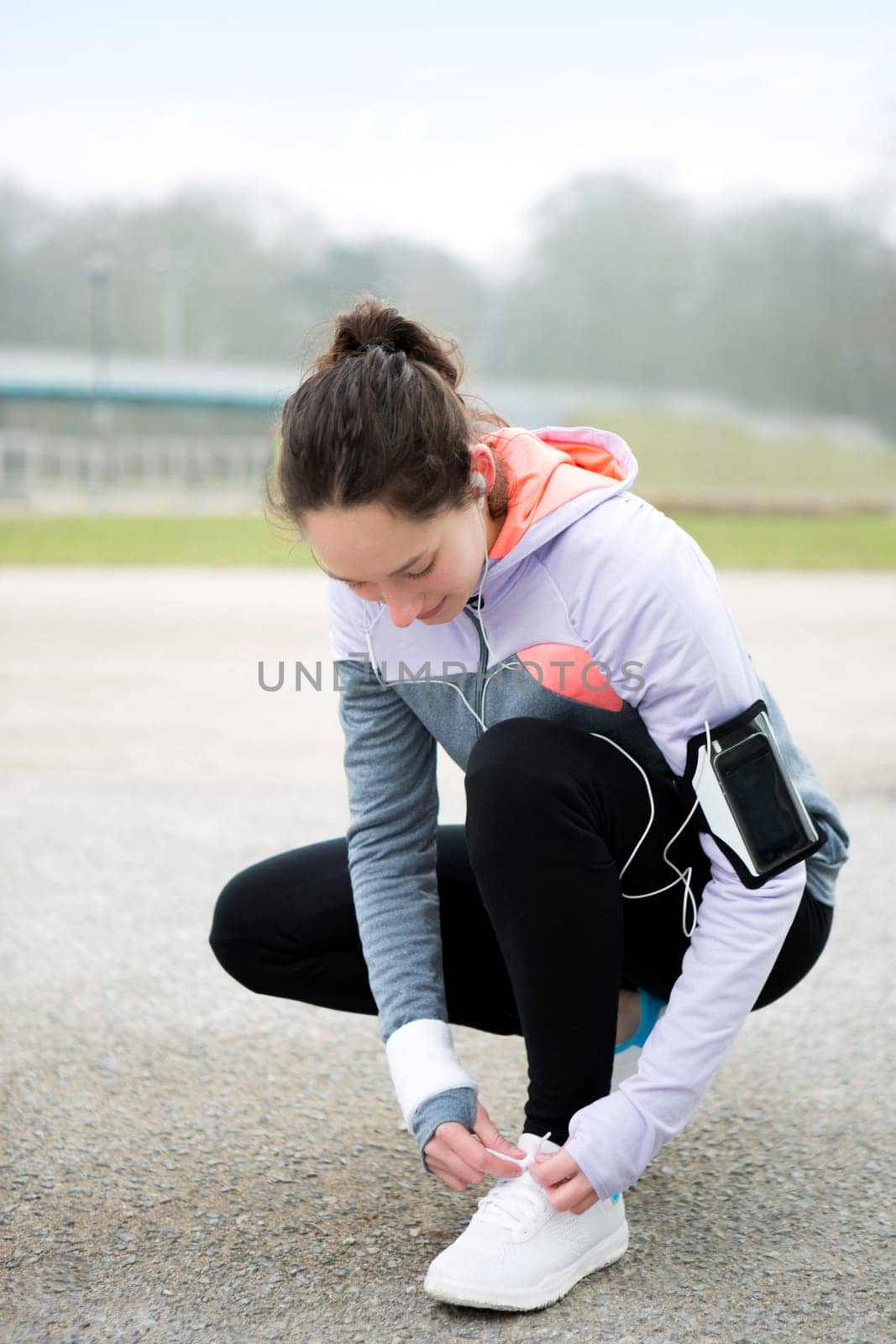 View of a Young attractive woman tying shoelaces before a running session