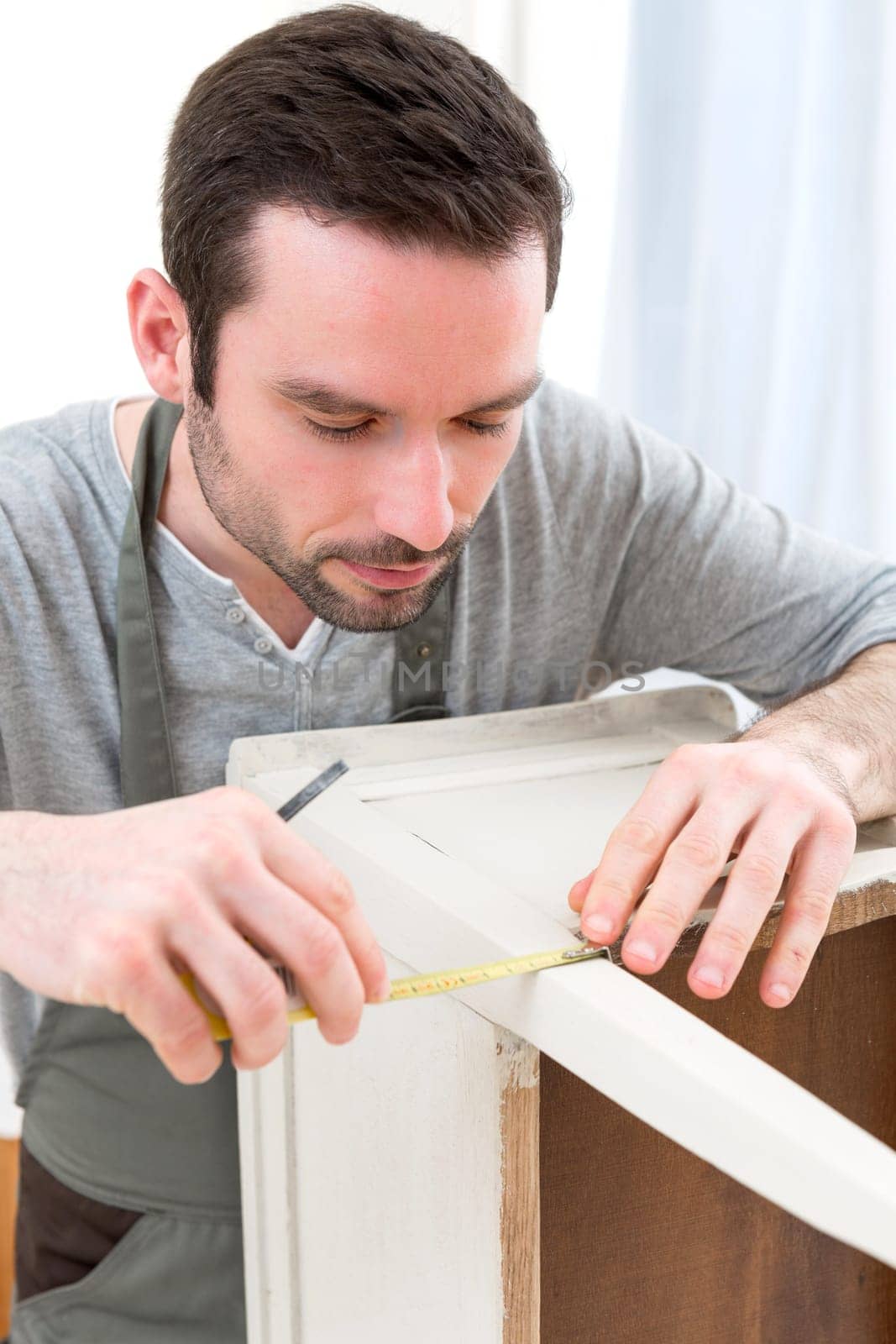 View of a Young attractive carpenter working in his workshop