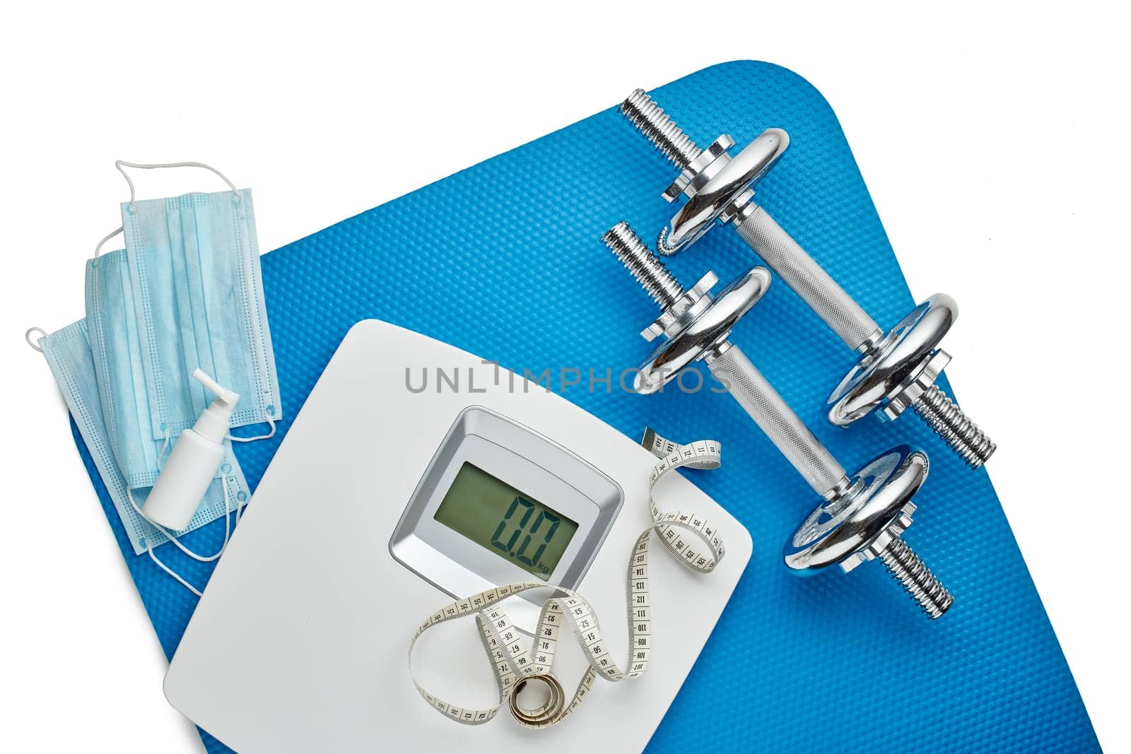 Sport equipment, scales, medical masks and sanitizer on white background. Top view, copy space. Fitness.  Isplation period. Weight and health control during quarantine. Concept of covid or coronavirus