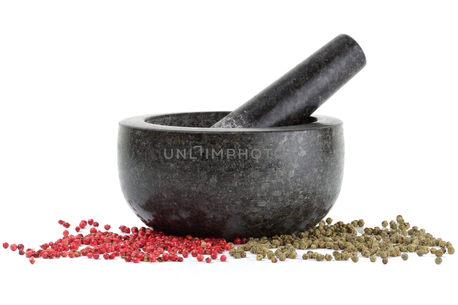 A side view of peppercorns with mortar and pestle isolated on white
