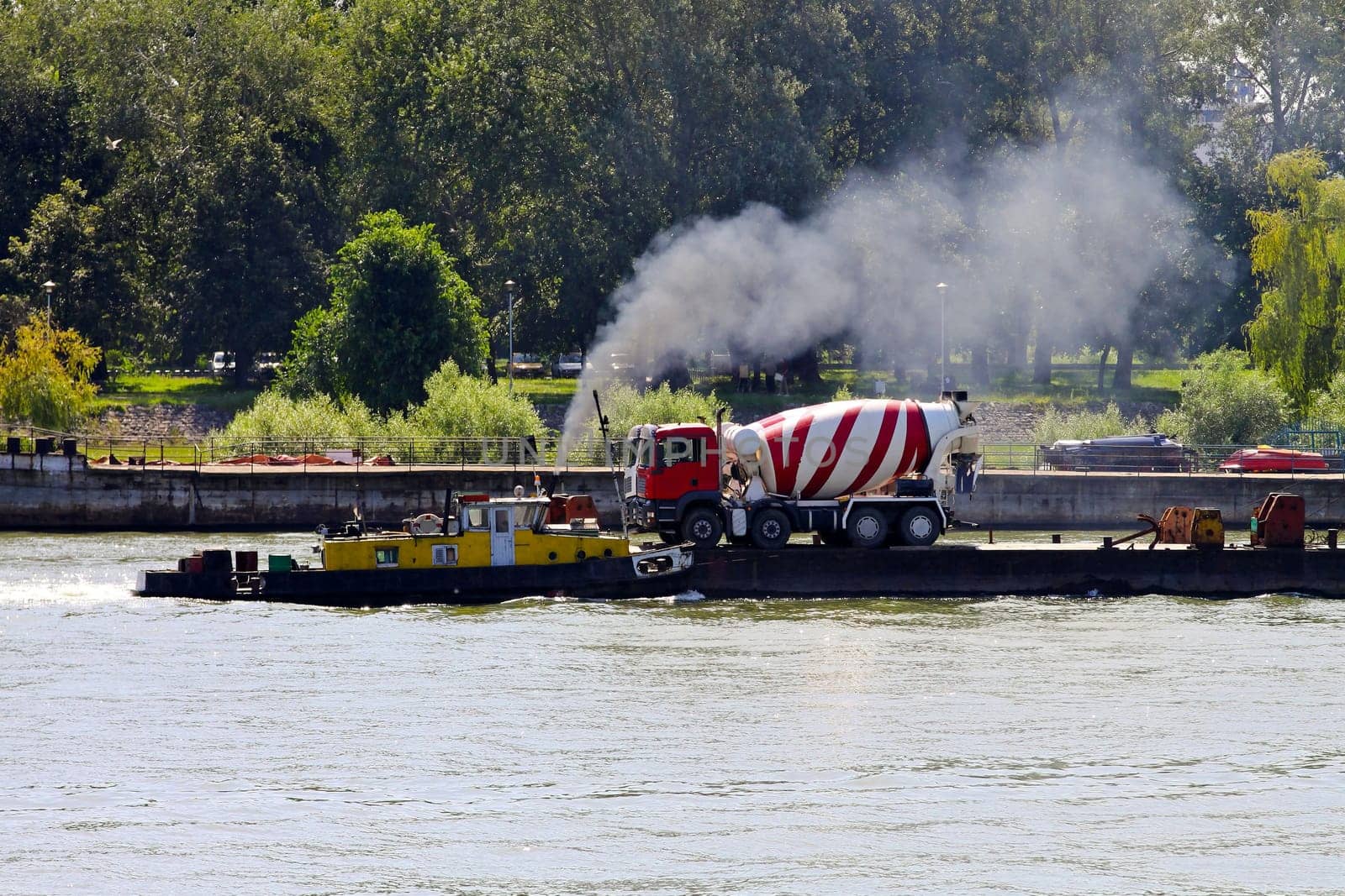 Concrete mixer truck delivery at river barge.