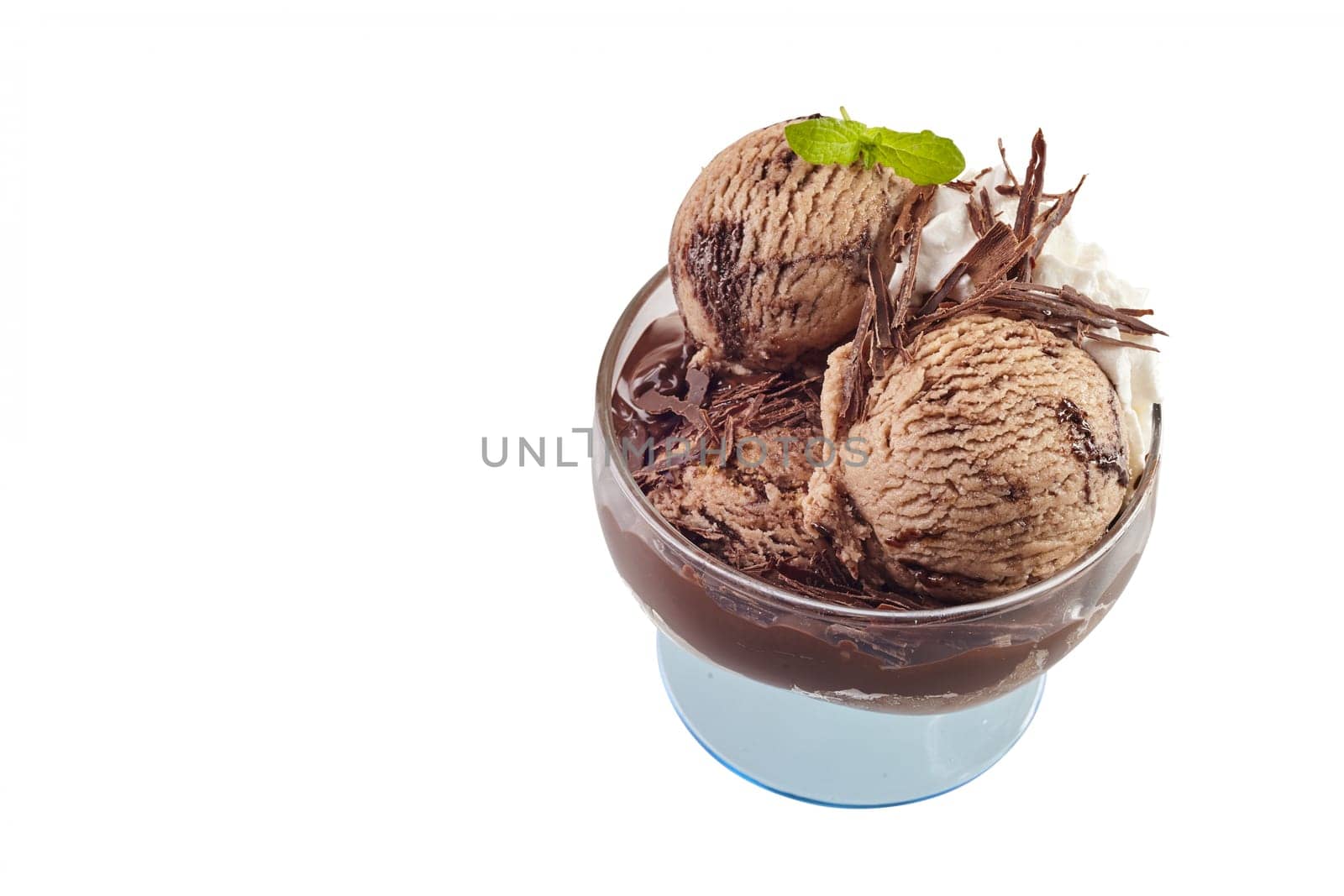 Delicious chocolate ice cream with flakes and fresh mint in a glass pedestal bowl in a high angle view isolated on white with copy space