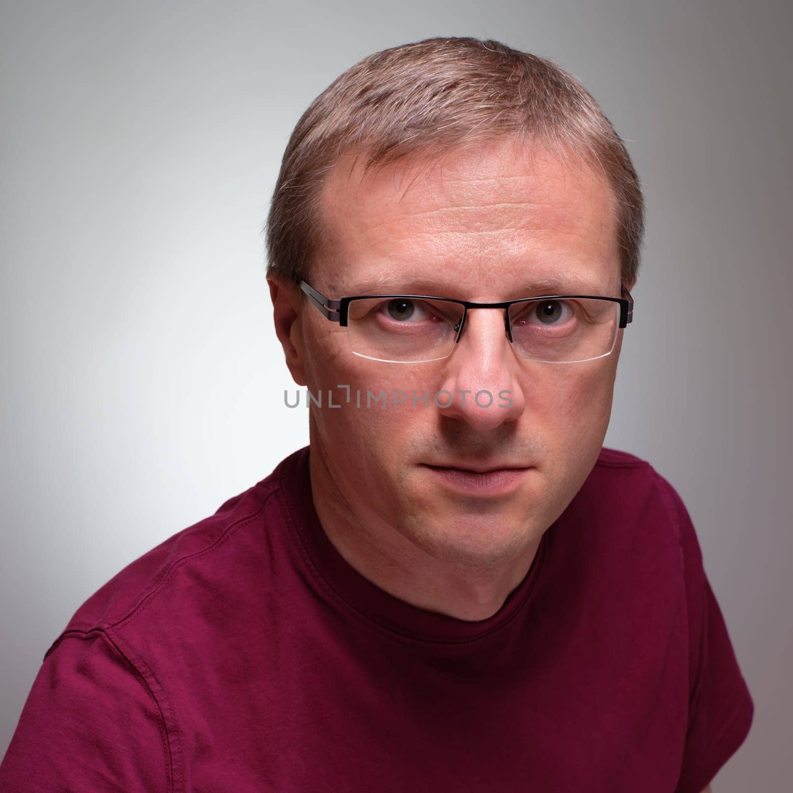 Man with glasses and skeptical glimpse background grey