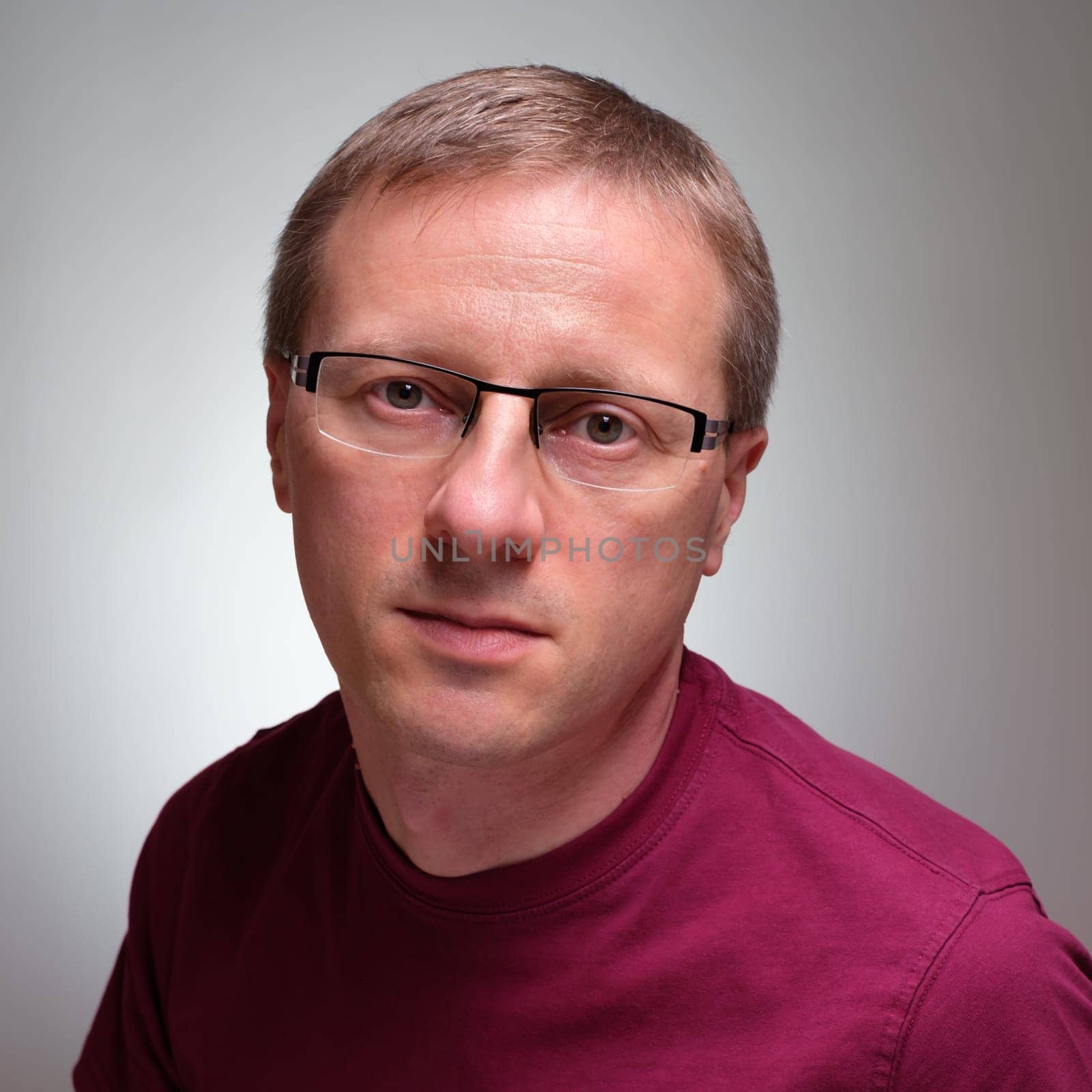 Caucasian man with glasses and serious glimpse grey background