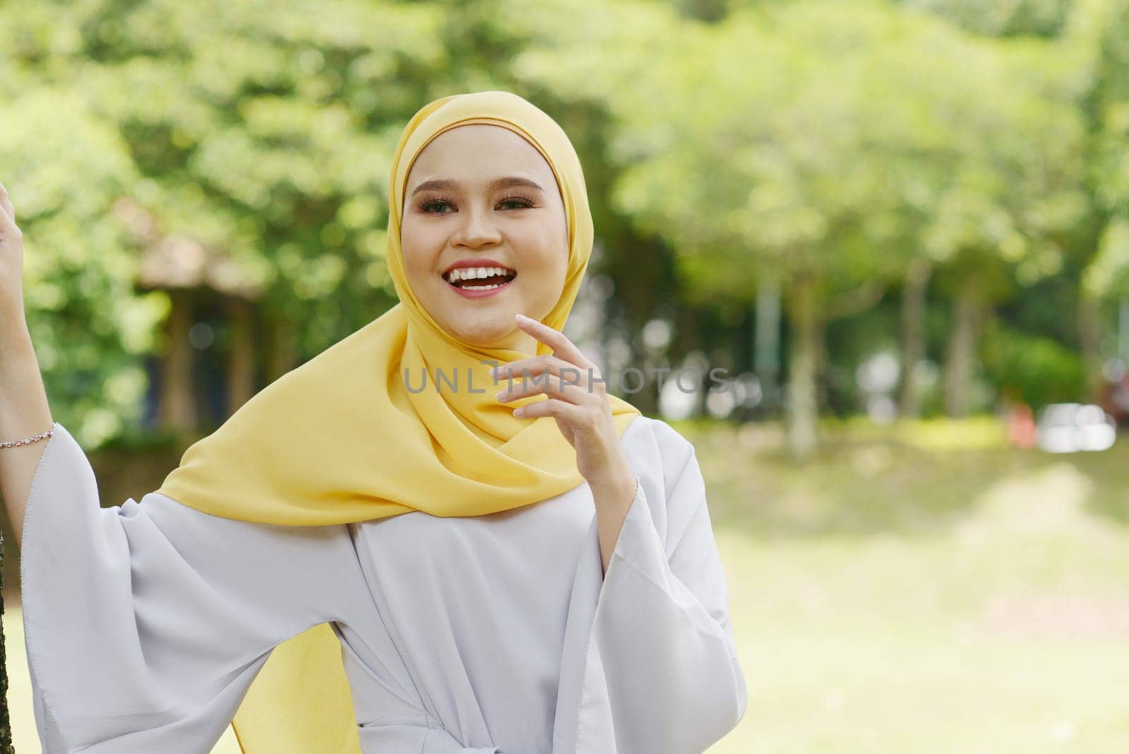 Portrait of cheerful Muslim girl in hijab, smiling at outdoor.