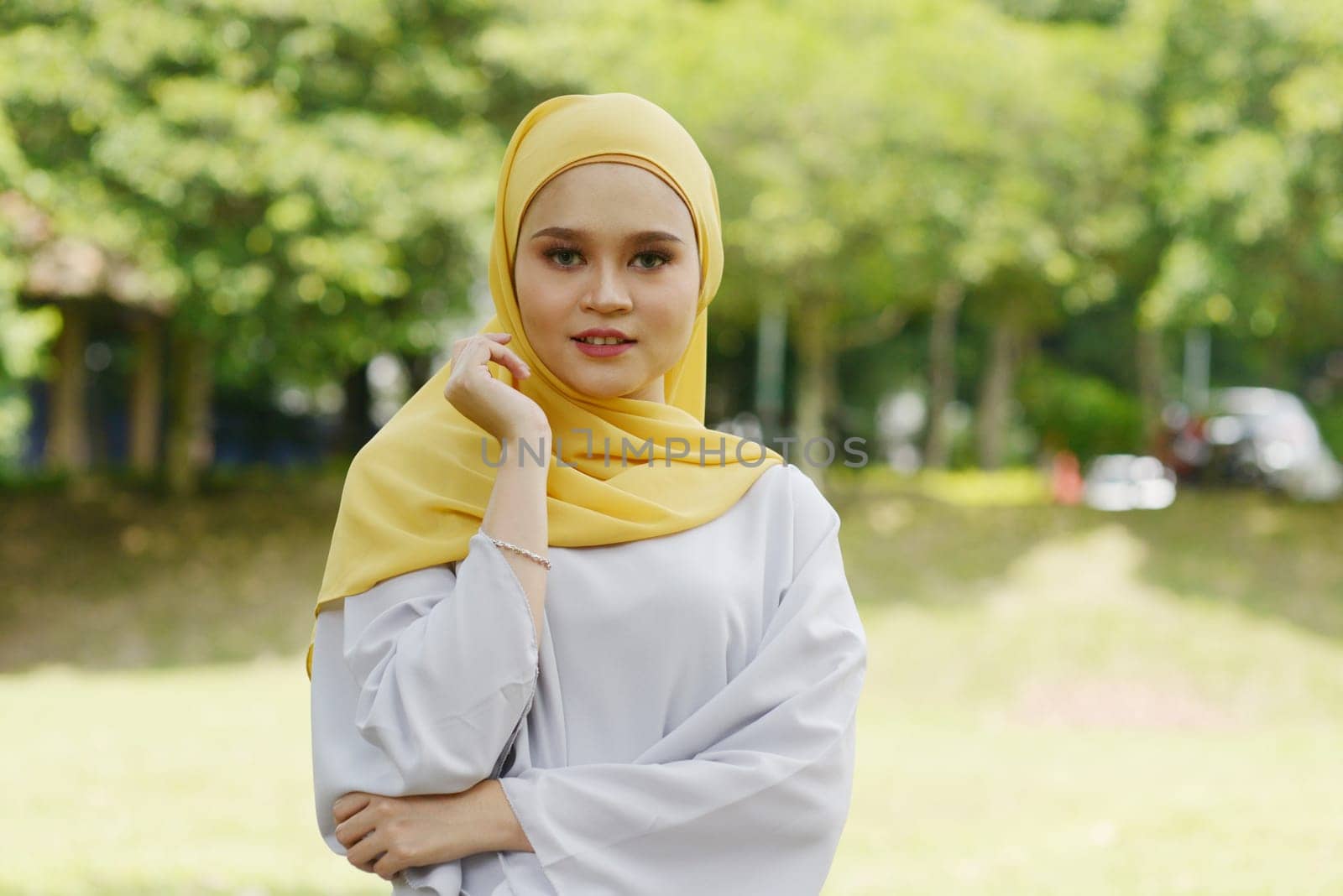 Portrait of cheerful Muslim girl in hijab, smiling at outdoor.