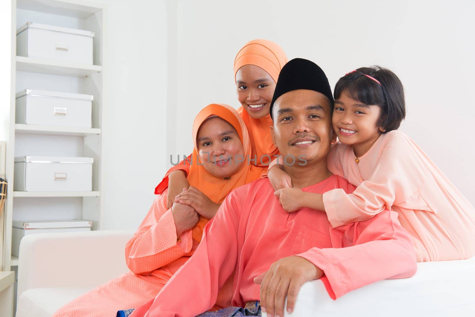 Happy Malay family portrait in traditional clothing during Hari Raya. Malaysian family lifestyle at home.