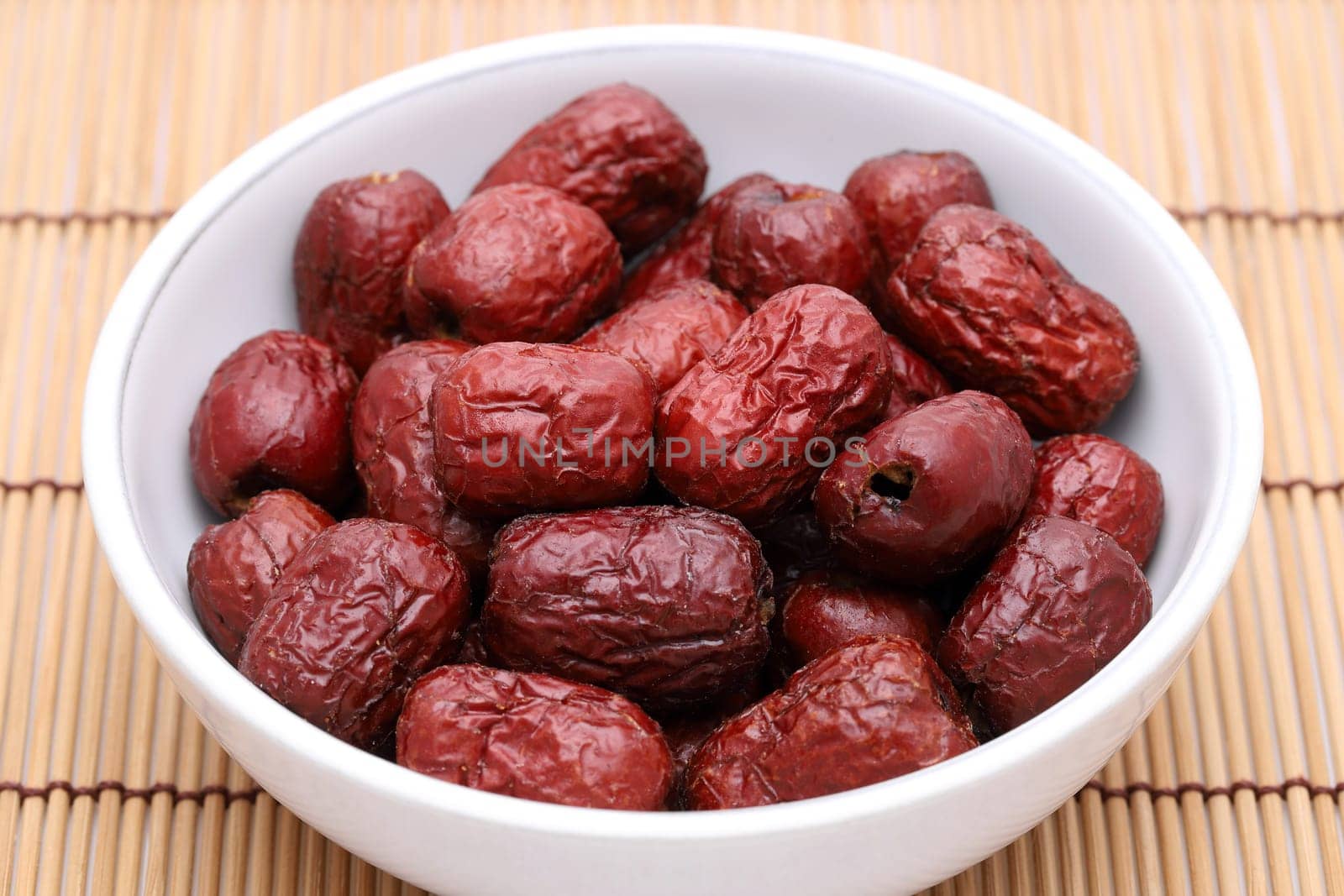 Dried Jujube, Chinese dried red date fruits in a bowl on bamboo table