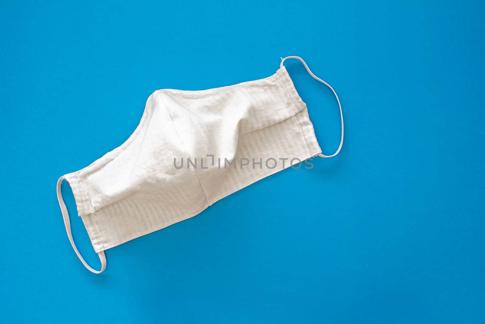 White homemade face mask for adults on a blue background