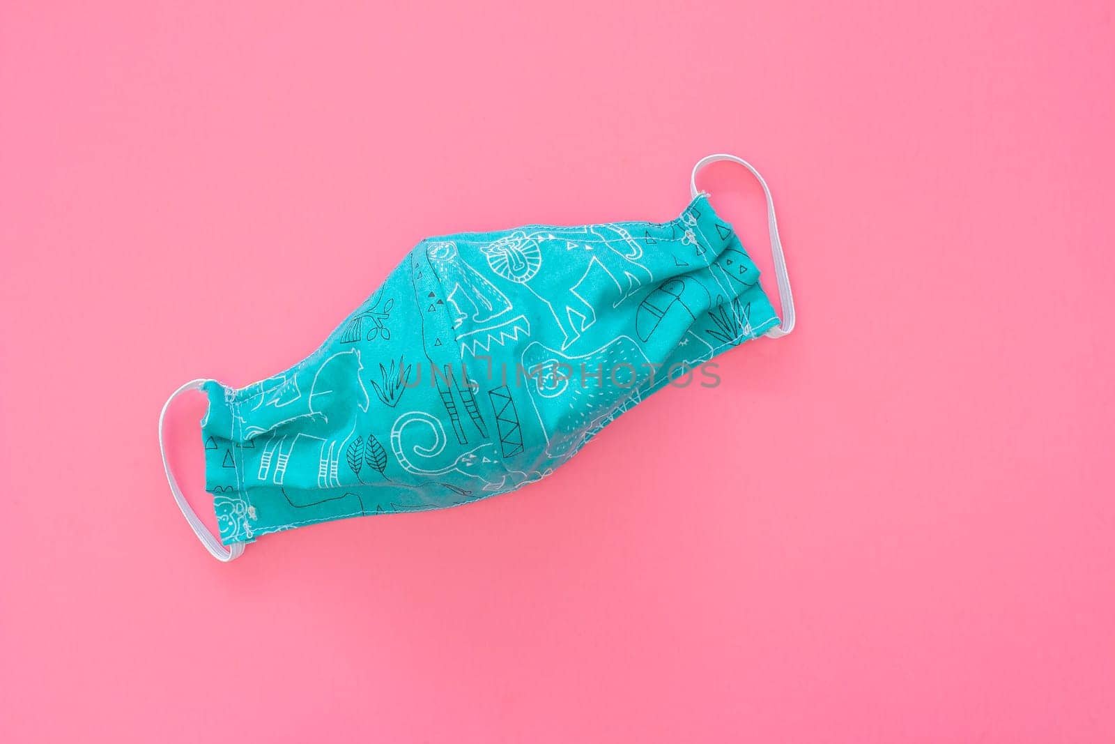 Blue, green homemade face mask for kids on a blue background