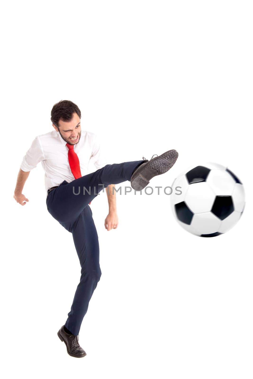 Businessman kicking a soccer ball isolated in white