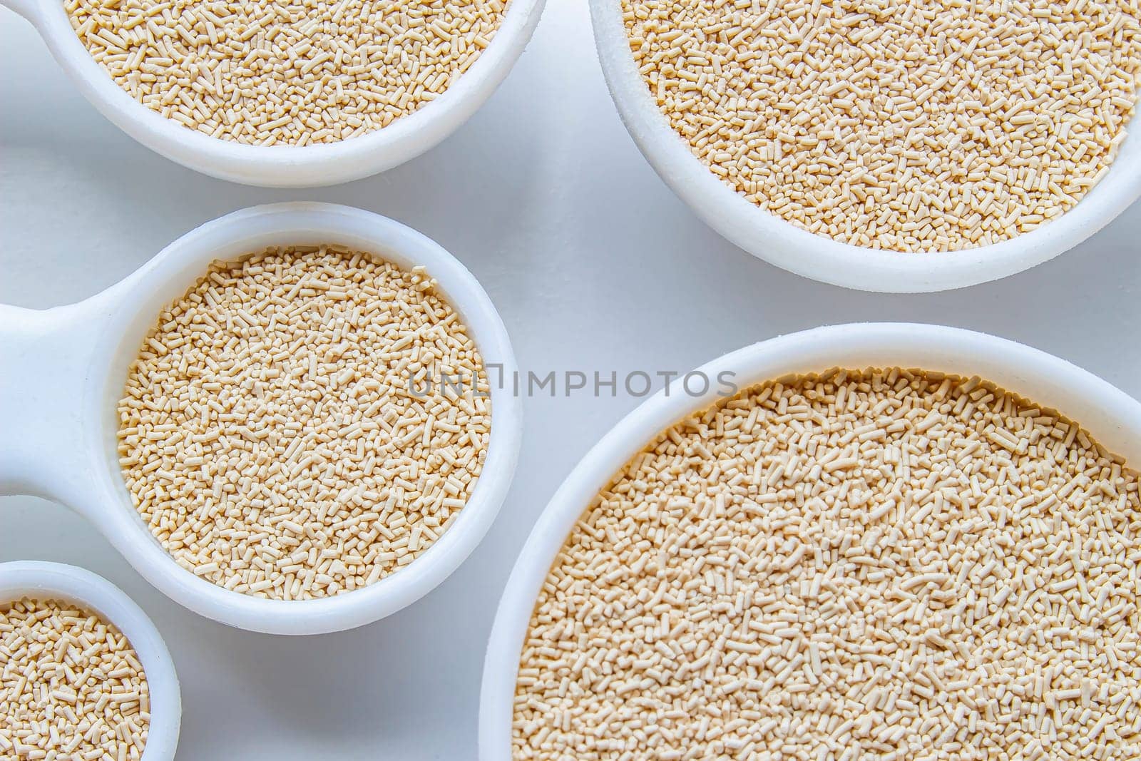 A close up of some measurement baking spoons with yeast on them