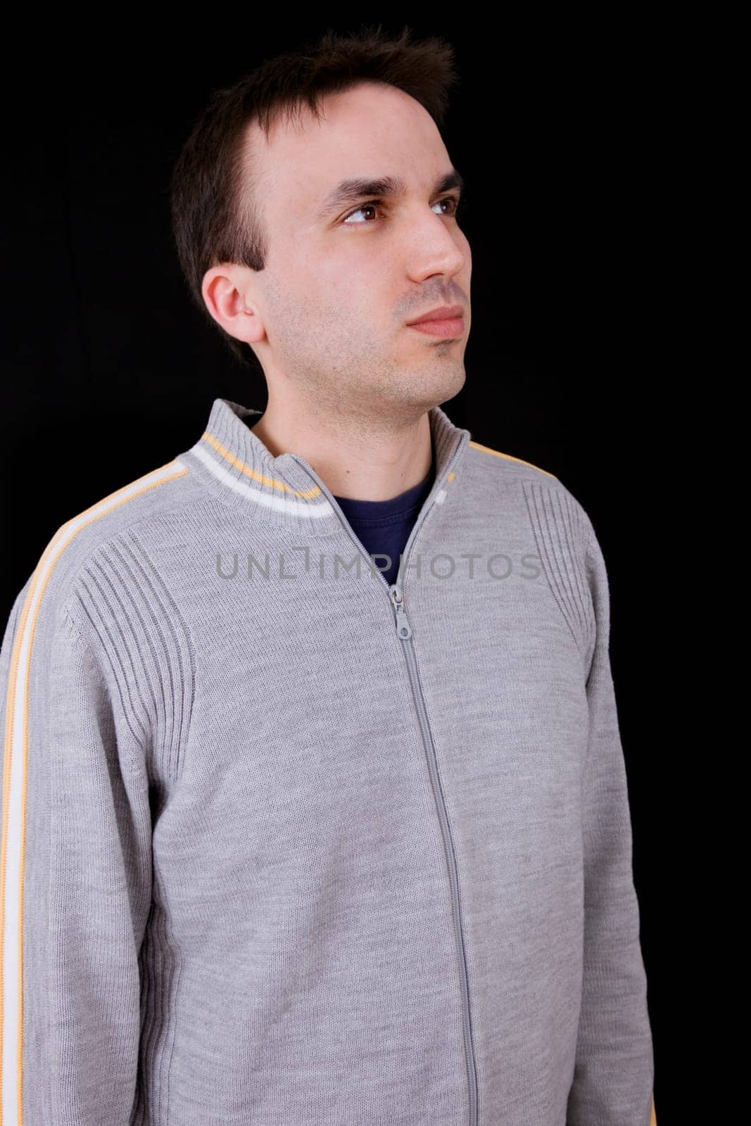 young casual man thinking on black background