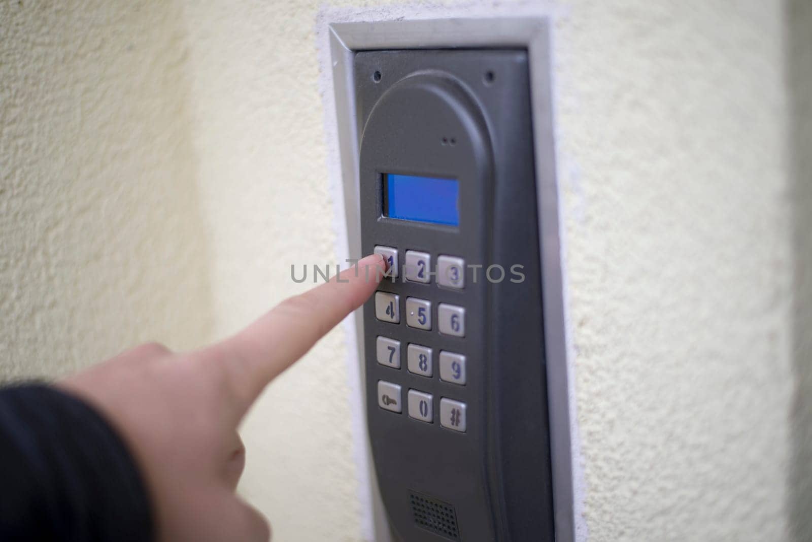 human finger pushing button of house intercom