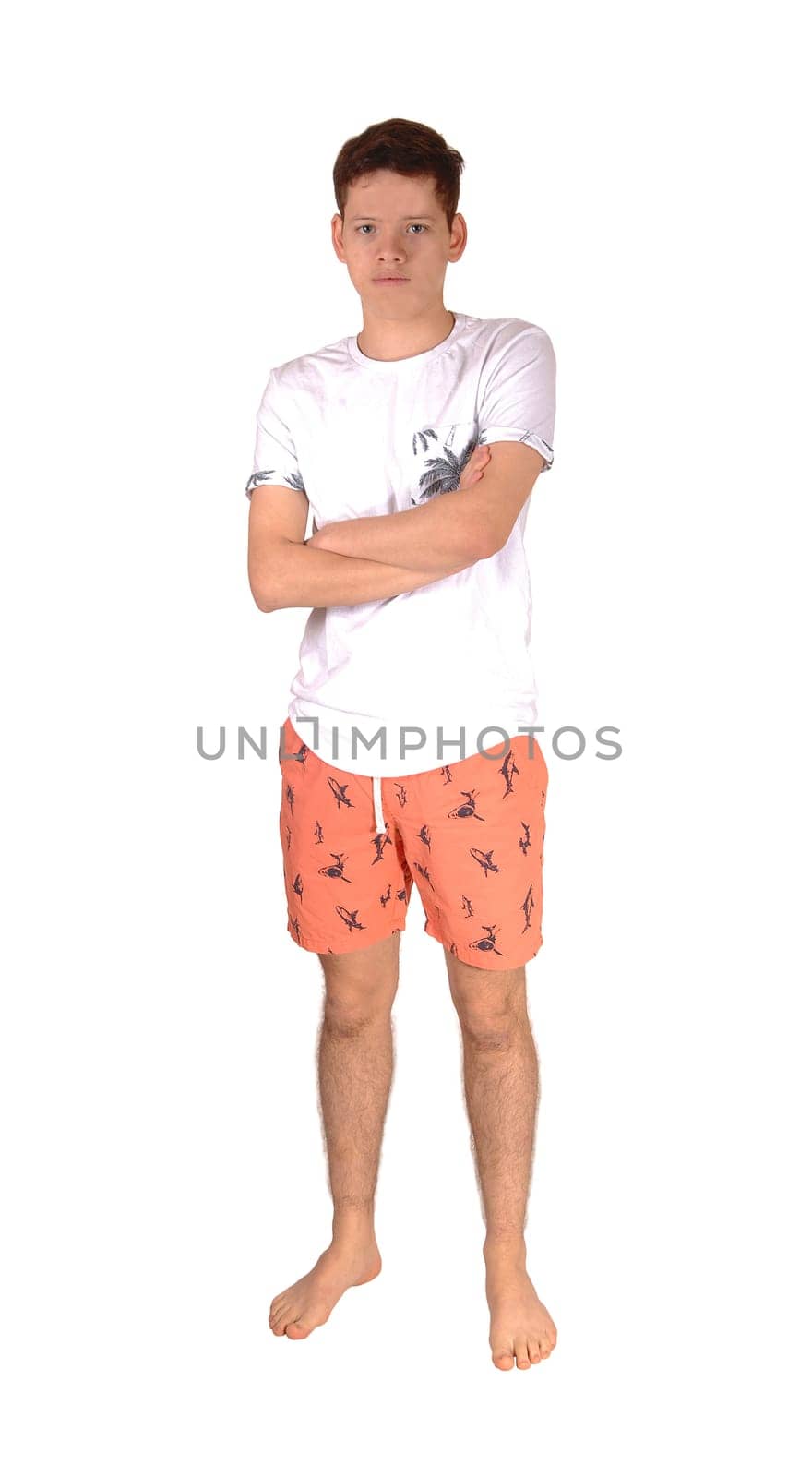 A teenager boy standing bare feet in the studio in his baiding suit with.his arms crossed, isolated for white background.