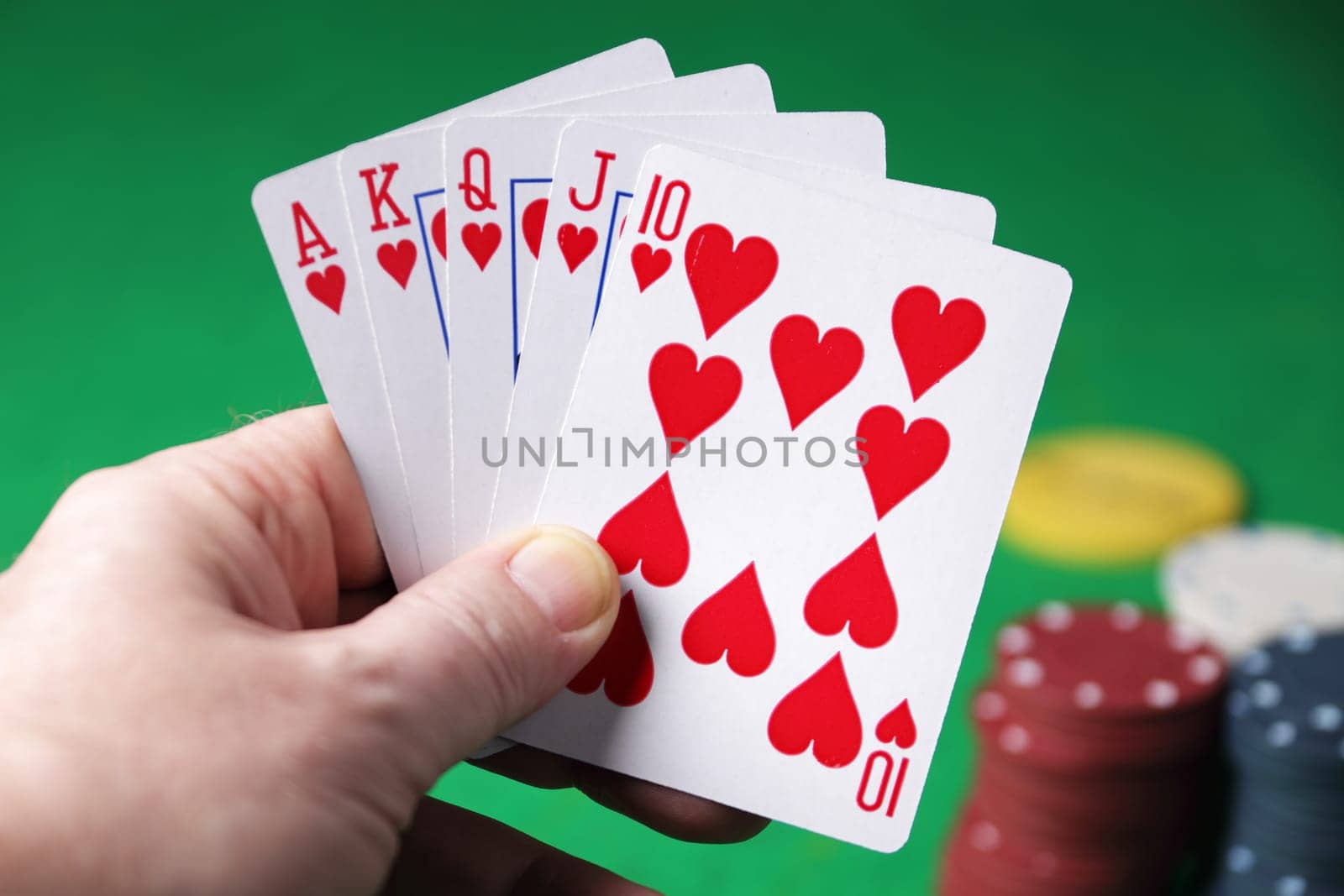 Holding a winning hand royal flush hearts selective focus