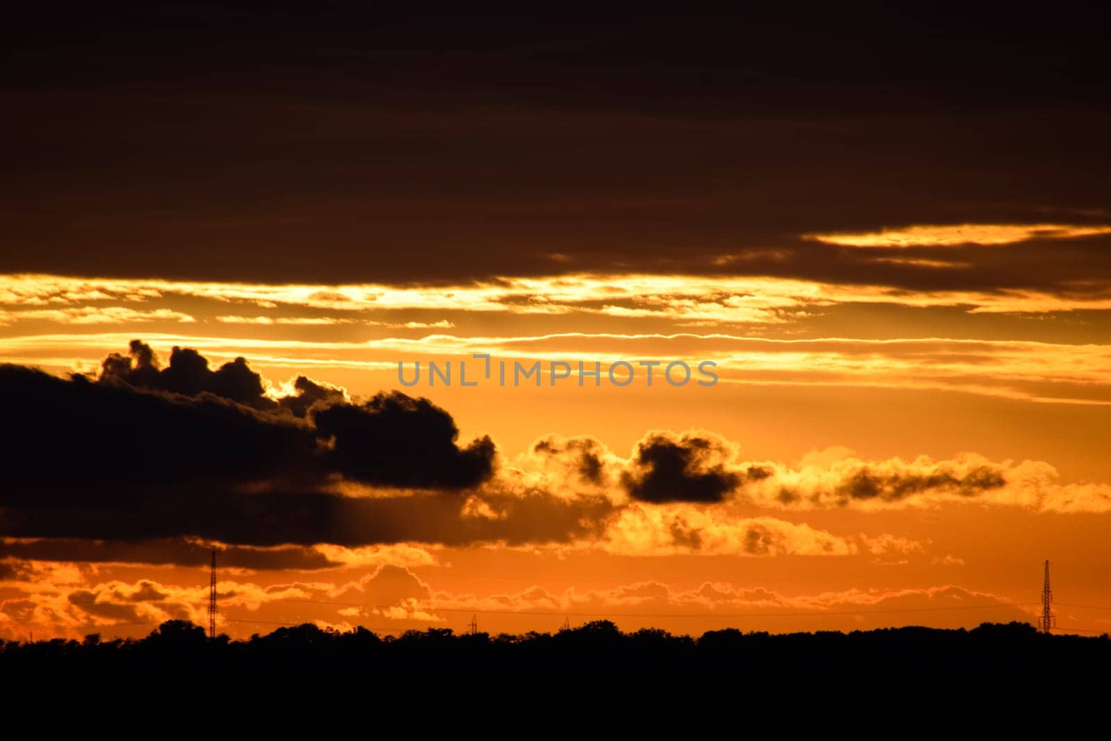 Beautiful orange bright sunset in black clouds.