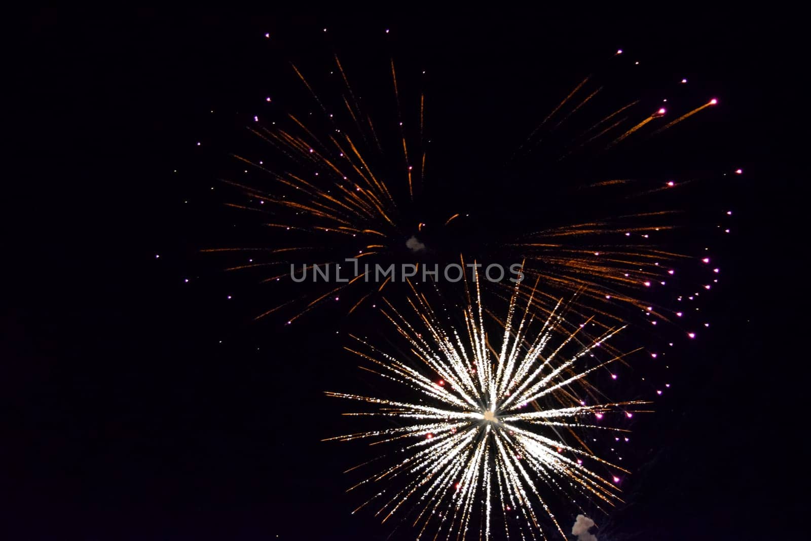 Festive salute in the night sky. Explosions of fireworks and pyrotechnics in the sky.
