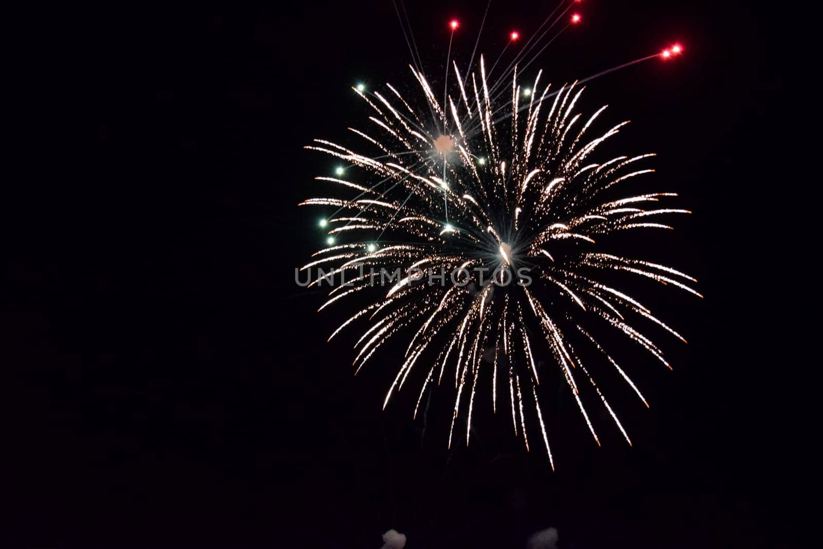 Festive salute in the night sky. Explosions of fireworks and pyrotechnics in the sky.
