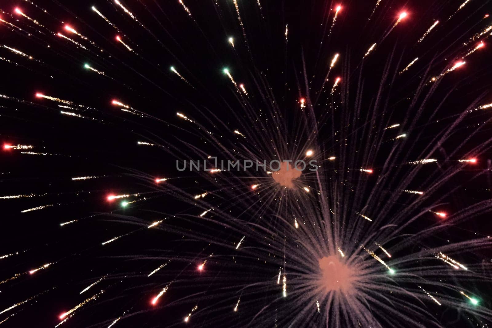 Festive salute in the night sky. Explosions of fireworks and pyrotechnics in the sky.