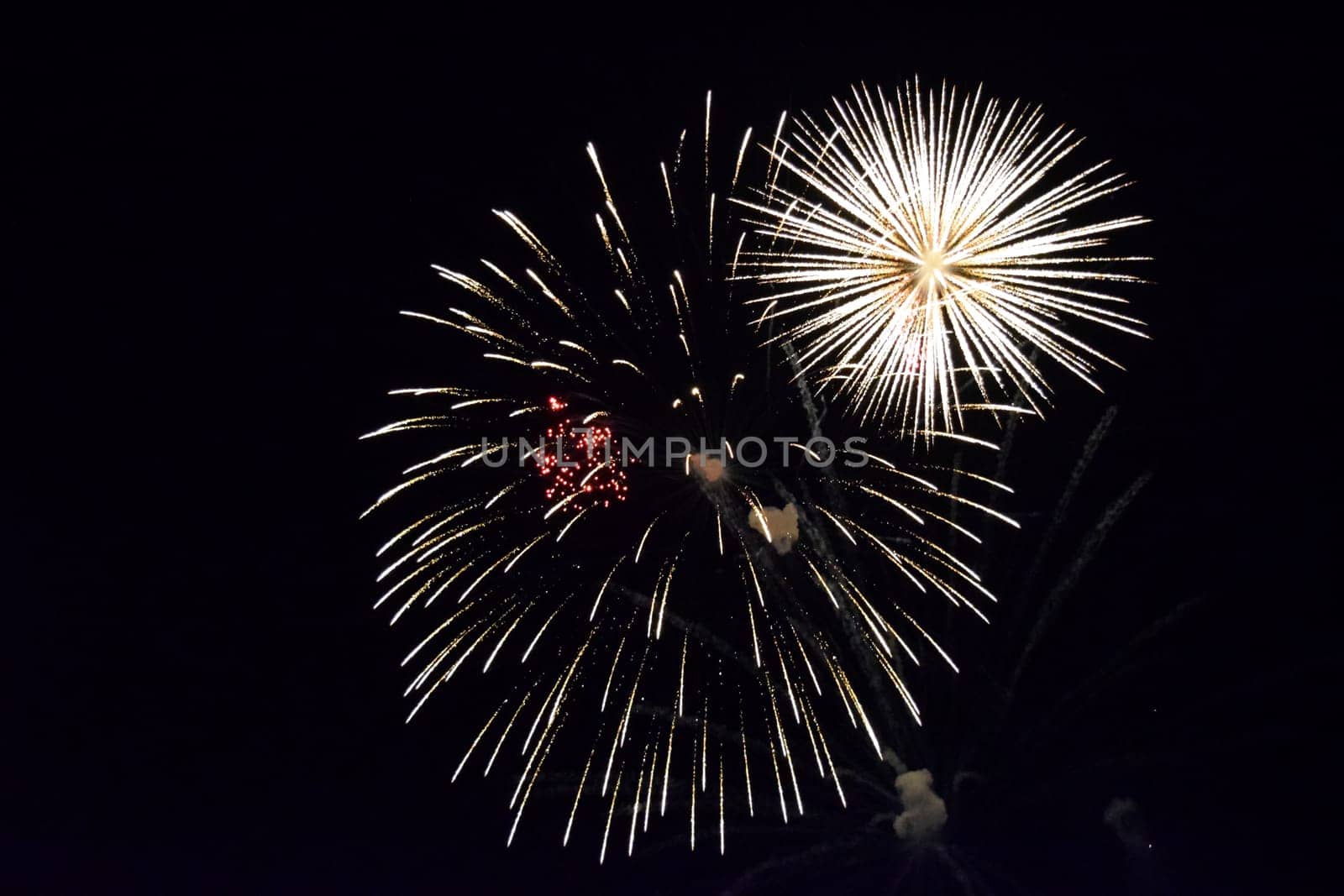 Festive salute in the night sky. Explosions of fireworks and pyrotechnics in the sky.