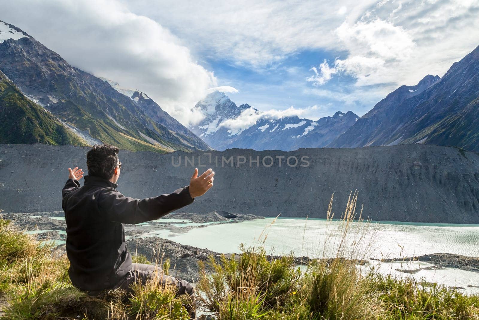 Man with open arms during at Mount Cook, New Zealand ..