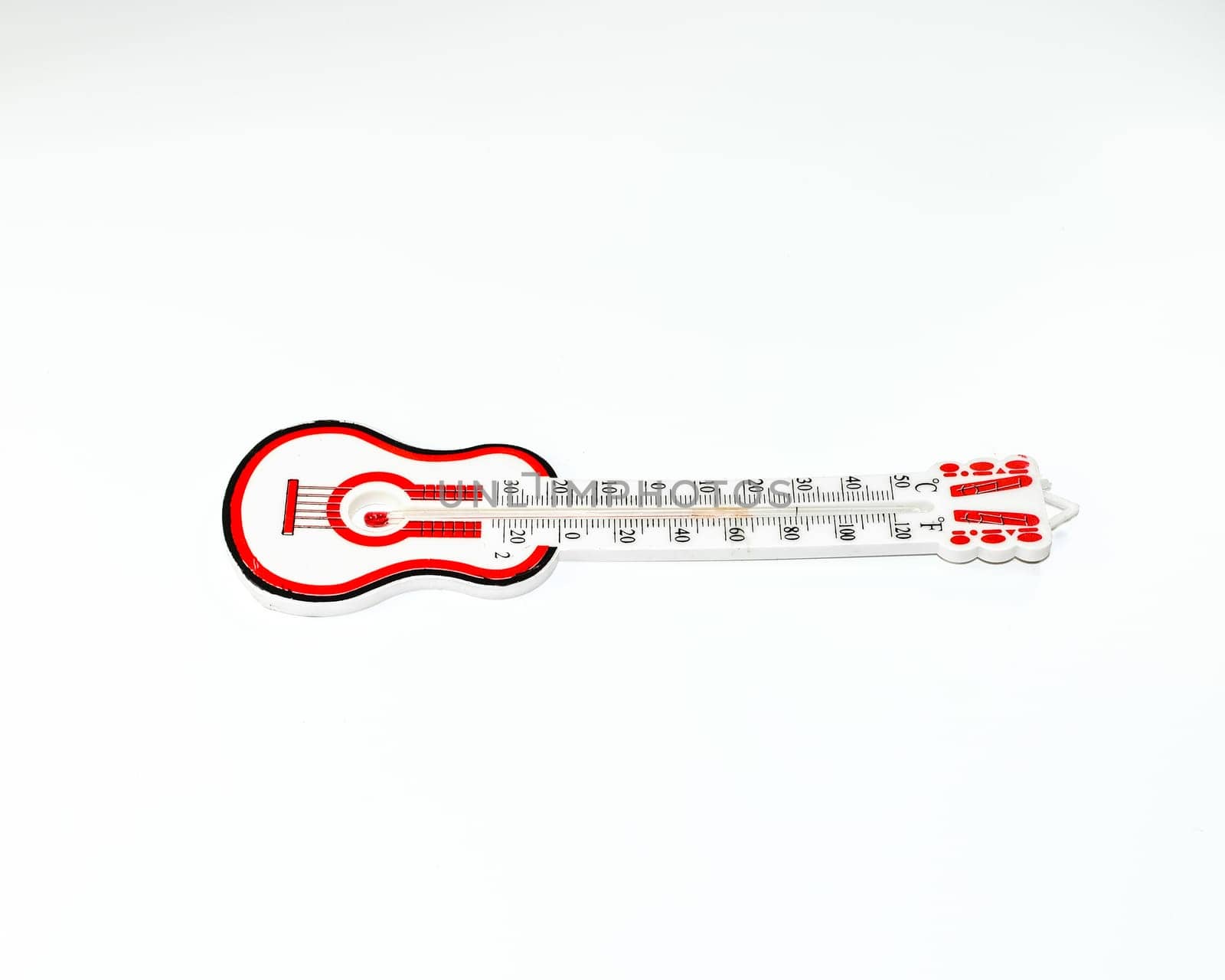 Alcohol thermometer with a red scale. Guitar shaped thermometer on a white background.