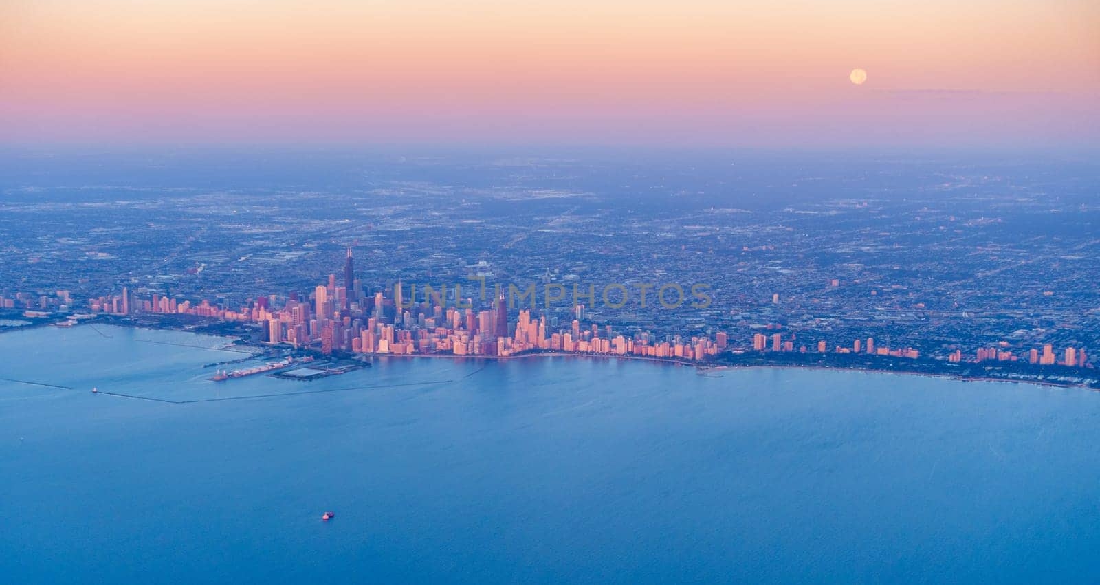 Scenic aerial view of full moon setting over Chicago downtown at sunrise