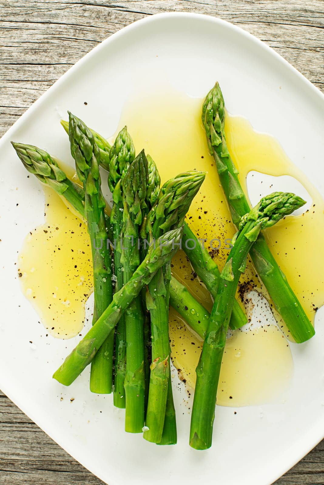 Asparagus. Green asparagus. Fresh boiled Asparagus with dressing on plate close up