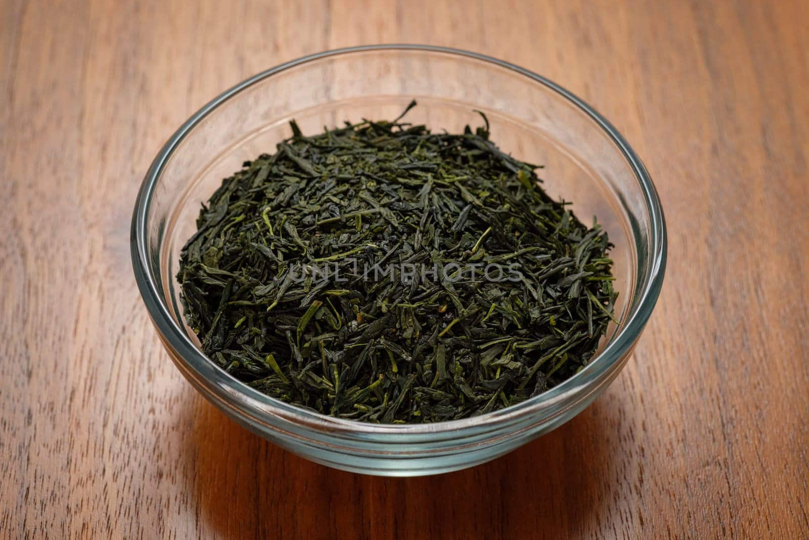 Green tea leaves in a glass bowl back lit
