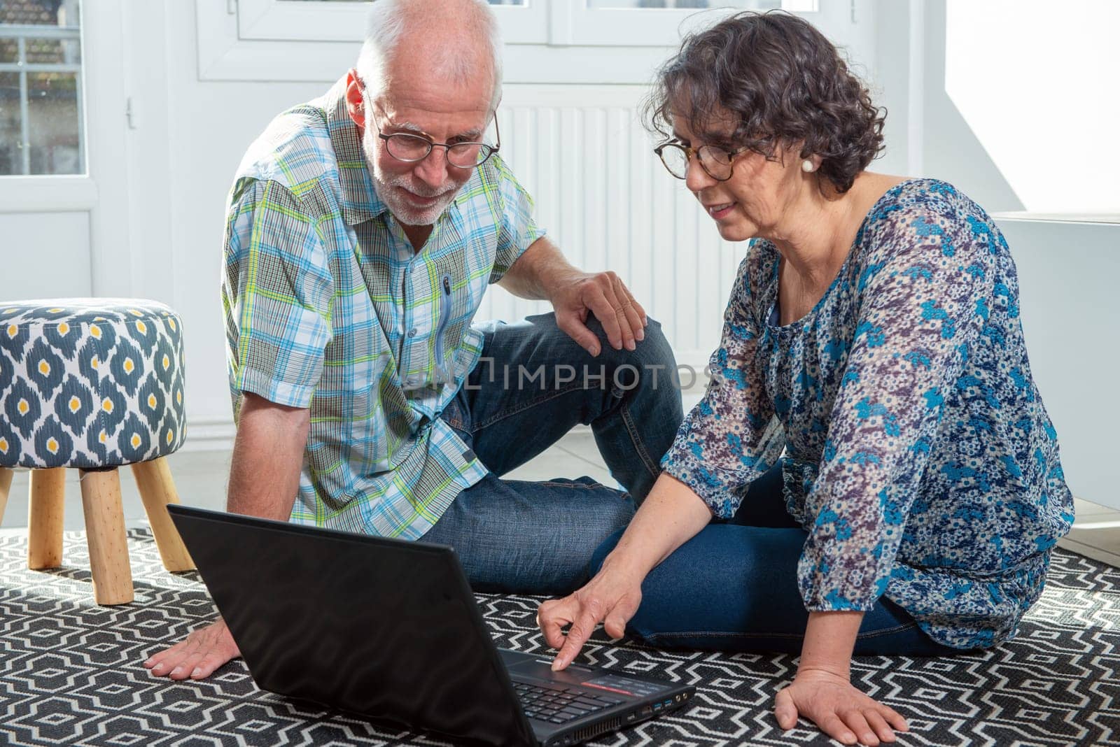 Couple senior using a computer laptop at home for online shopping
