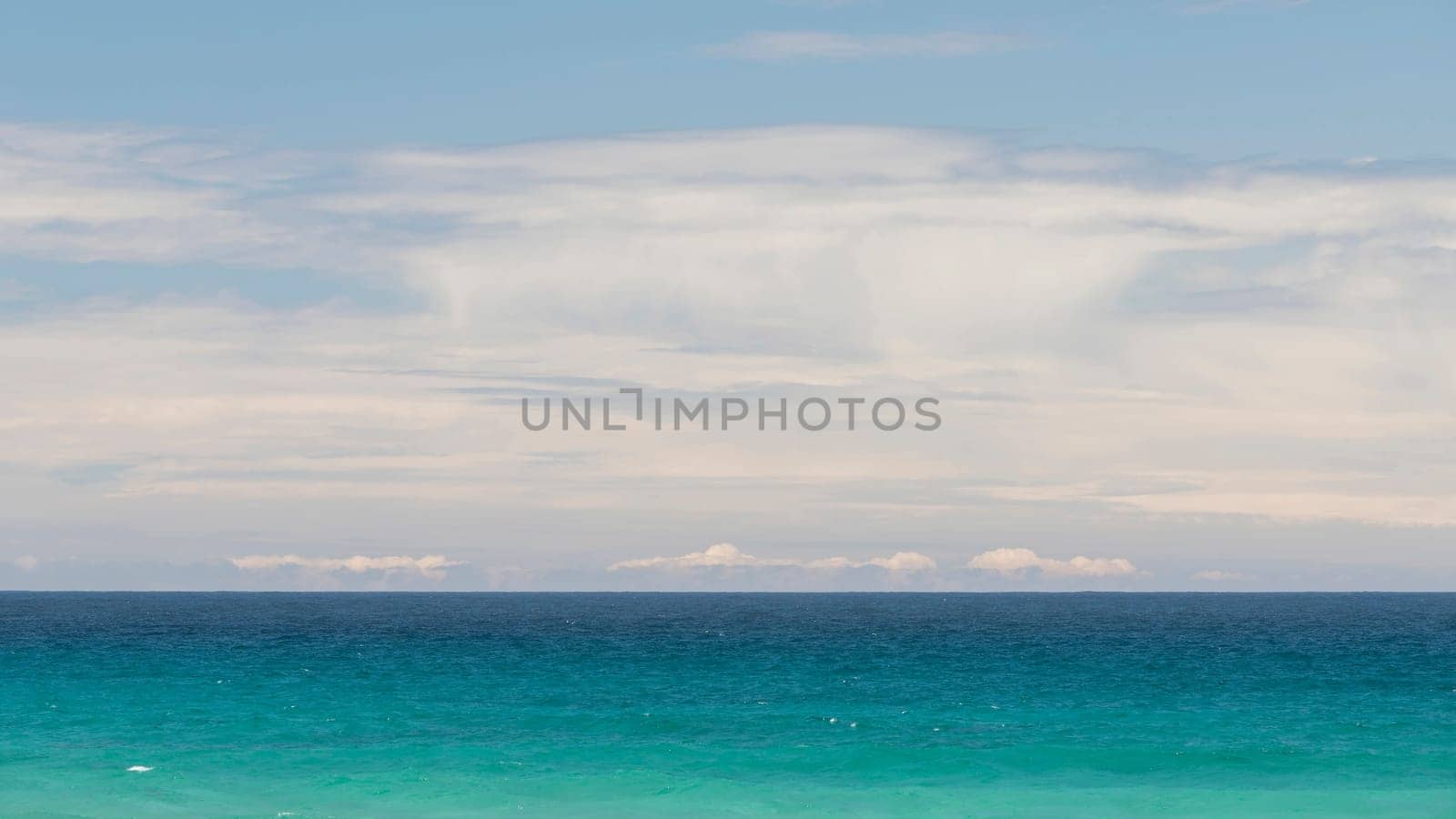 Minimalist seascape with turquoise waters and cloudy sky