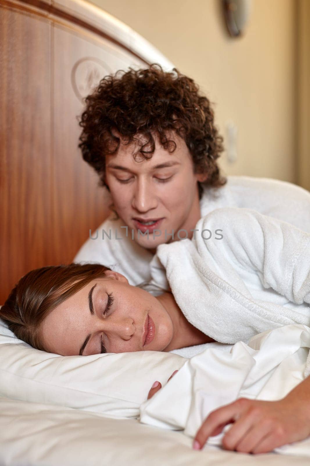 Happy young family  lies in the bed at home.