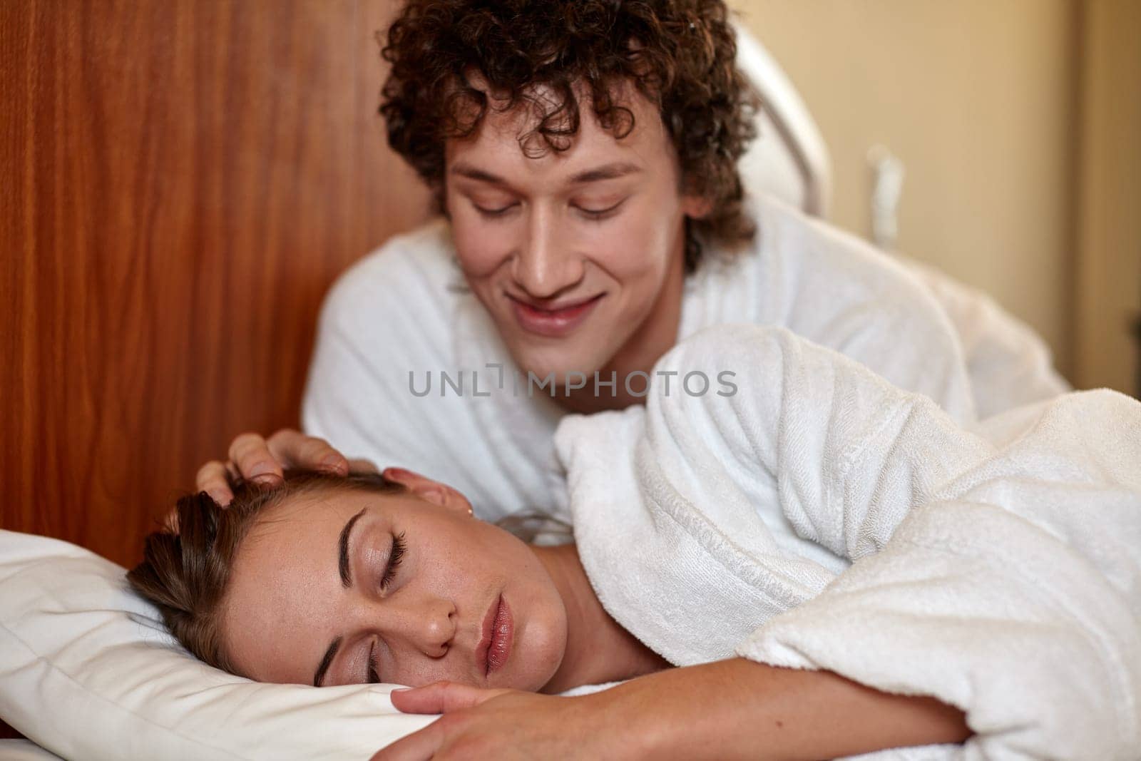 Happy young family  lies in the bed at home.