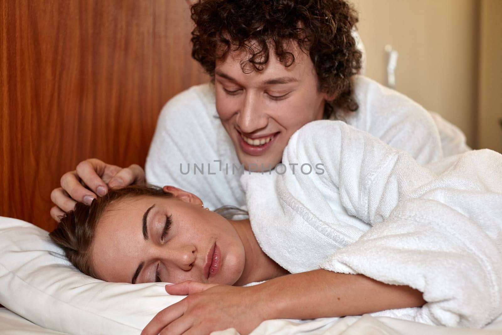 Happy young family  lies in the bed at home.
