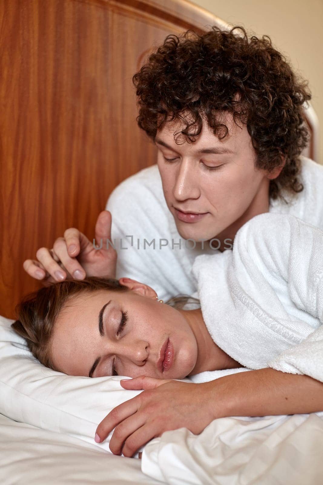 Happy young family  lies in the bed at home.