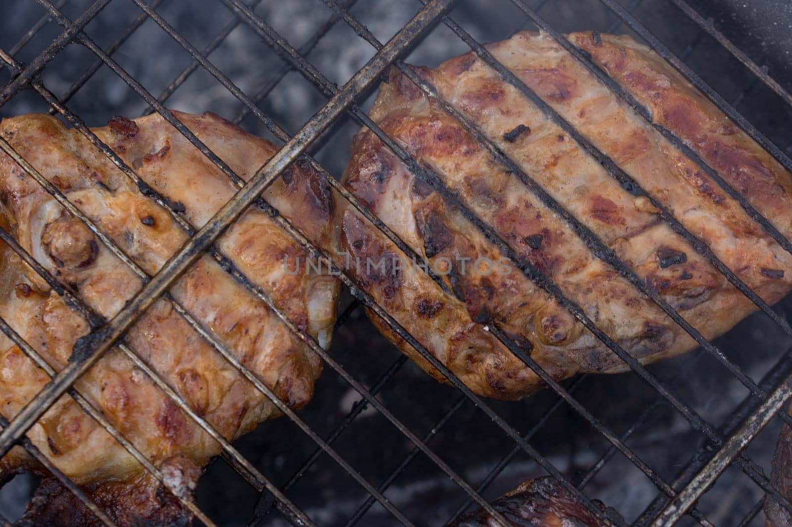 Delicious meat, grilled on a grill with a delicious crust cooked in the open air