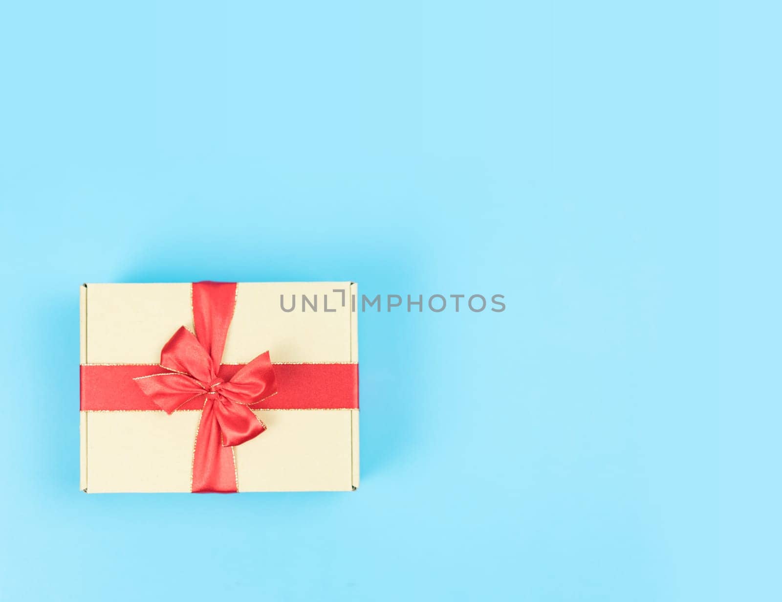 Gift box with red ribbon on color background. Object for Christmas day or Birthday present.