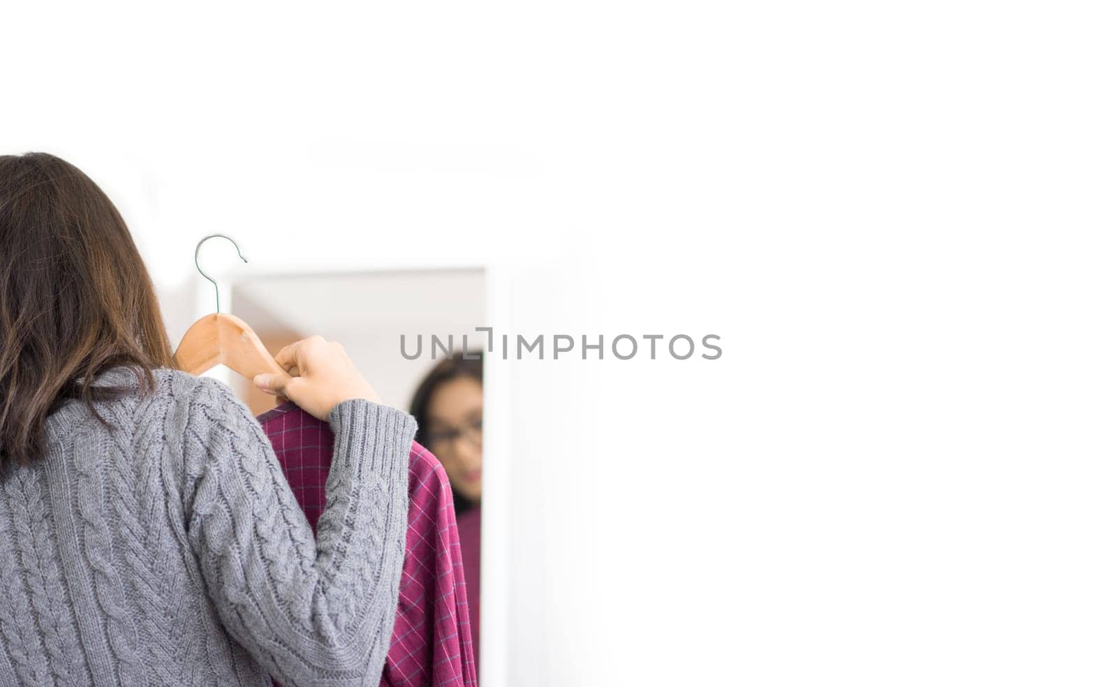 Woman choosing clothes in dressing room.  Beauty and fashion concept.