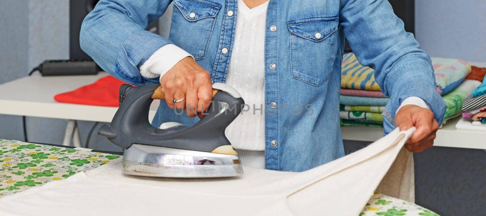 a close up of hands of woman doing the ironing