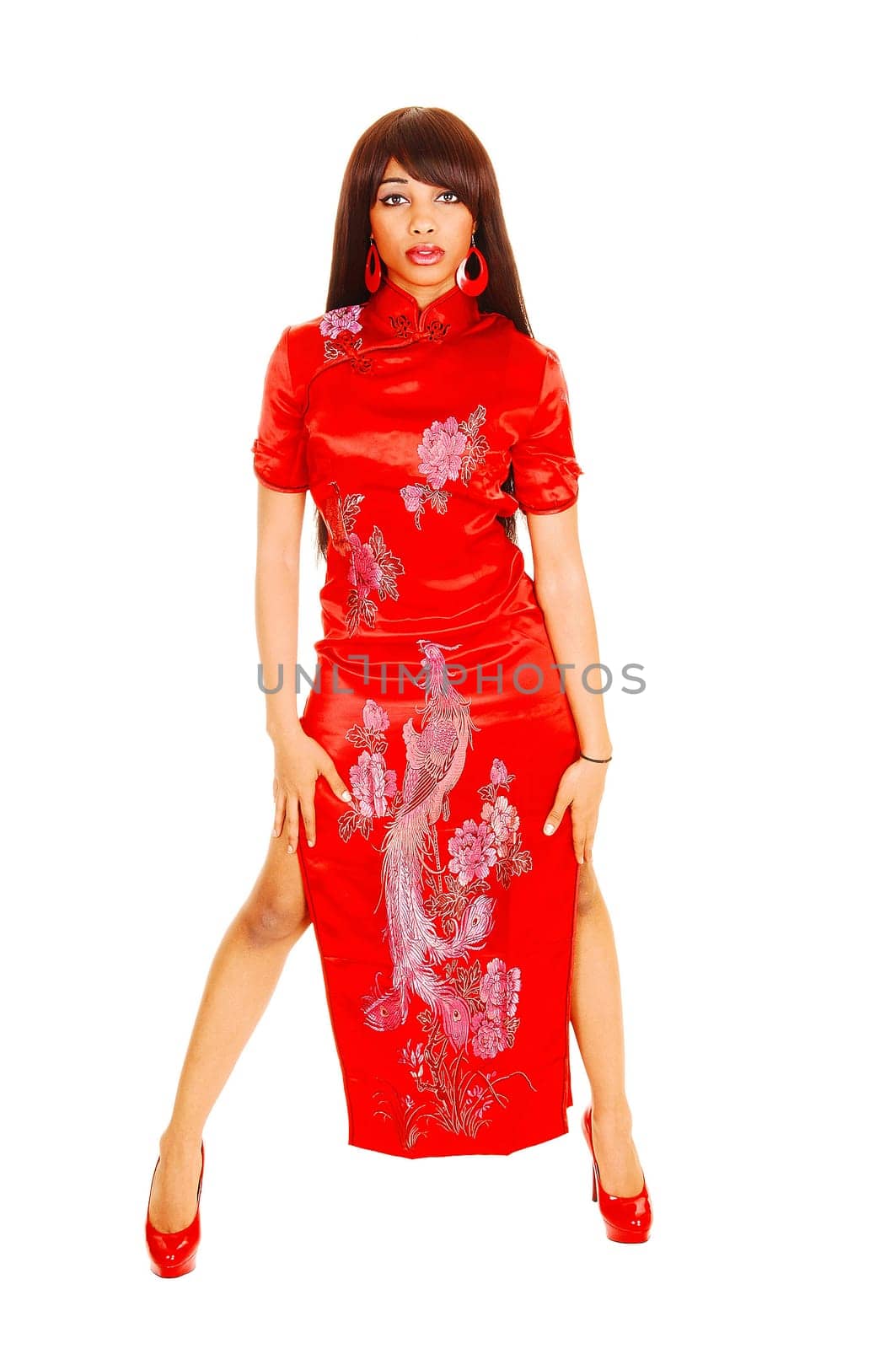 Gorgeous young woman standing in a Chinese red long dress in the.studio with her long hair, isolated for white background.
