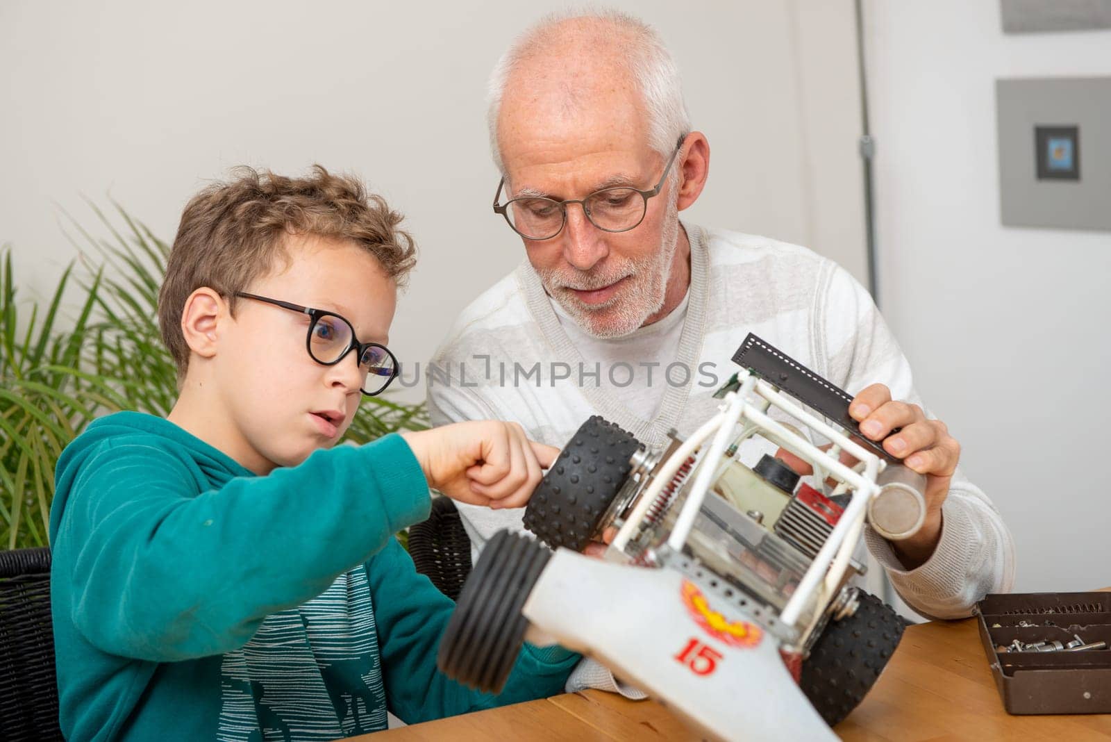 grandpa and son little boy repairing a model radio-controlled car