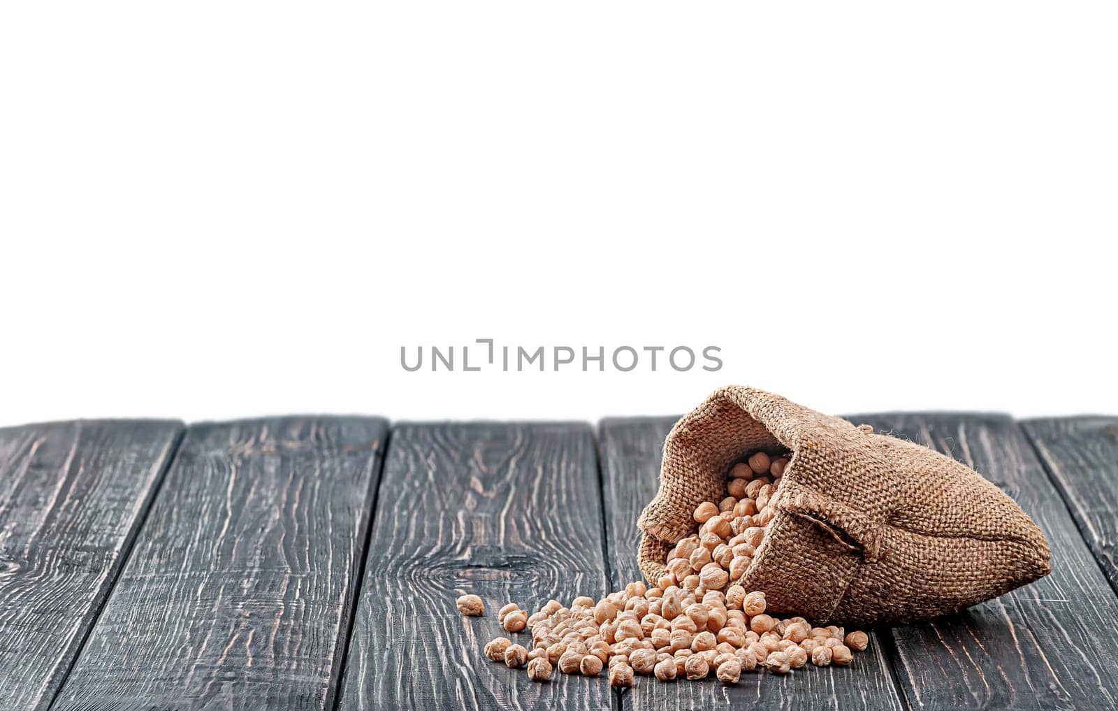 Chickpea spill out of the bag on table isolated on white background